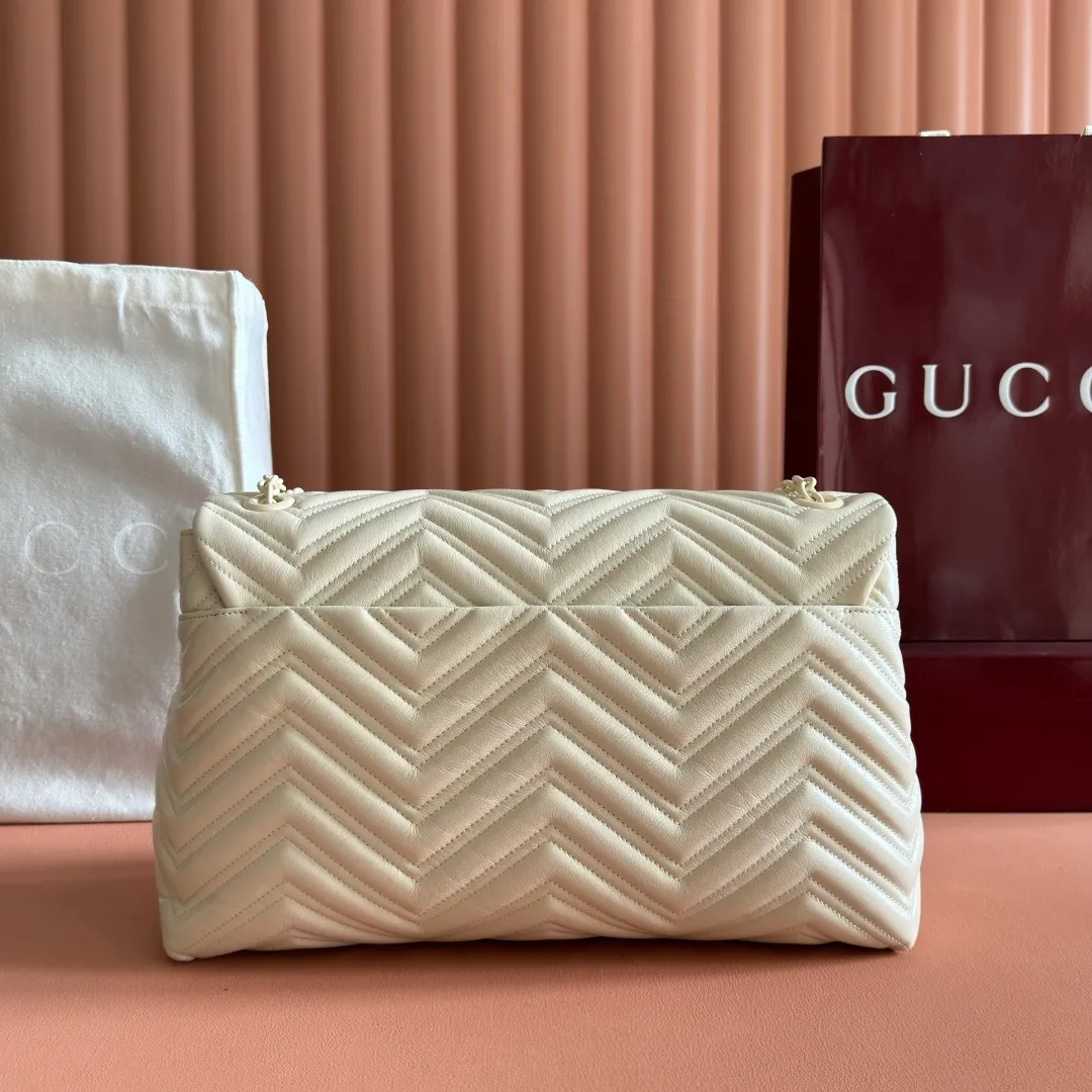 p1960. 💋💋💋【With full set of original counter packaging】2025 autumn and winter series, the brand's iconic GG Marmont series is ingeniously integrated with classic double G elements and faceted chain straps, creating a soft yet crisp silhouette design. This piece is crafted from soft, lightweight quilted V-shaped calfskin leather and features tonal enamel hardware and chain. Black soft lightweight quilted V-shaped calfskin leather. Tonal enamel hardware and chain. Black rayon lining. Double G. Interior: Zippered pocket. Exterior: Back open pocket. Magnetic closure. Ident.: 850659. Dimensions: 37.5cm (W) x 21cm (H) x 9cm (D) Color: White/Soft Leather. Made in Italy