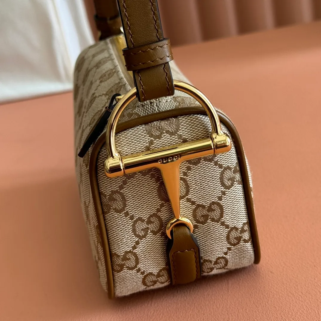 p900💋💋💋【With full set of original counter packaging】The brand interprets iconic elements from a contemporary perspective and re-presents the Gucci half-horse bit design. It uses soft cow leather that fits the body shape to inject new style into classic accessories. This mini bag is crafted from soft grained leather and features a half horsebit detail on the side. Green grained soft leather. Light gold tone hardware. Tonal cotton and linen blend lining. Half horsebit buckle. Calf leather shoulder strap (23cm high). Zip closure. Ident.: 860784. Dimensions: 19cm (width) x 19.5cm (height) x 9cm (depth) Weight: approx. 272g Color: Brown cloth