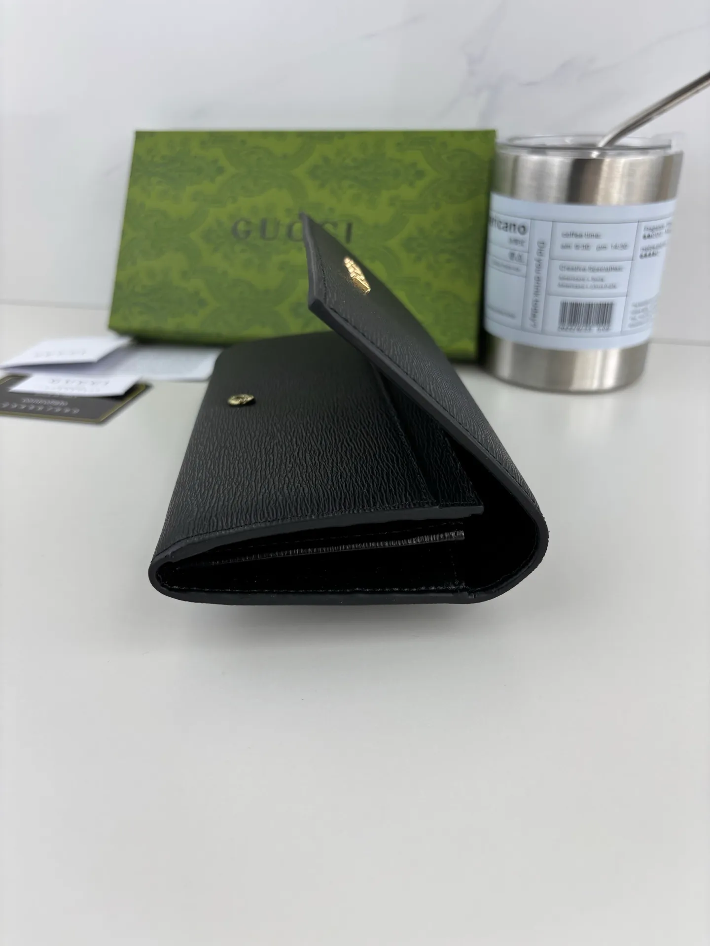 💰170 GUCCl long clip wallet with handwritten Gucci logo. Exploring self-expression with unlimited possibilities has become the spiritual connotation of brand design. Crafted from black leather, this long clip is embellished with a gold-toned handwritten Gucci logo-shaped hardware, adding a touch of the brand's signature charm to the entire design. Black leather, gold-tone hardware, taffeta lining, script Gucci logo detail. Interior: Twelve card compartments, two bill compartments, two separate internal compartments and a zippered coin pocket, this classic piece features snap fastening Style number: 772638 Dimensions: 19cm x 10cm x 3.5cm Colour: Black