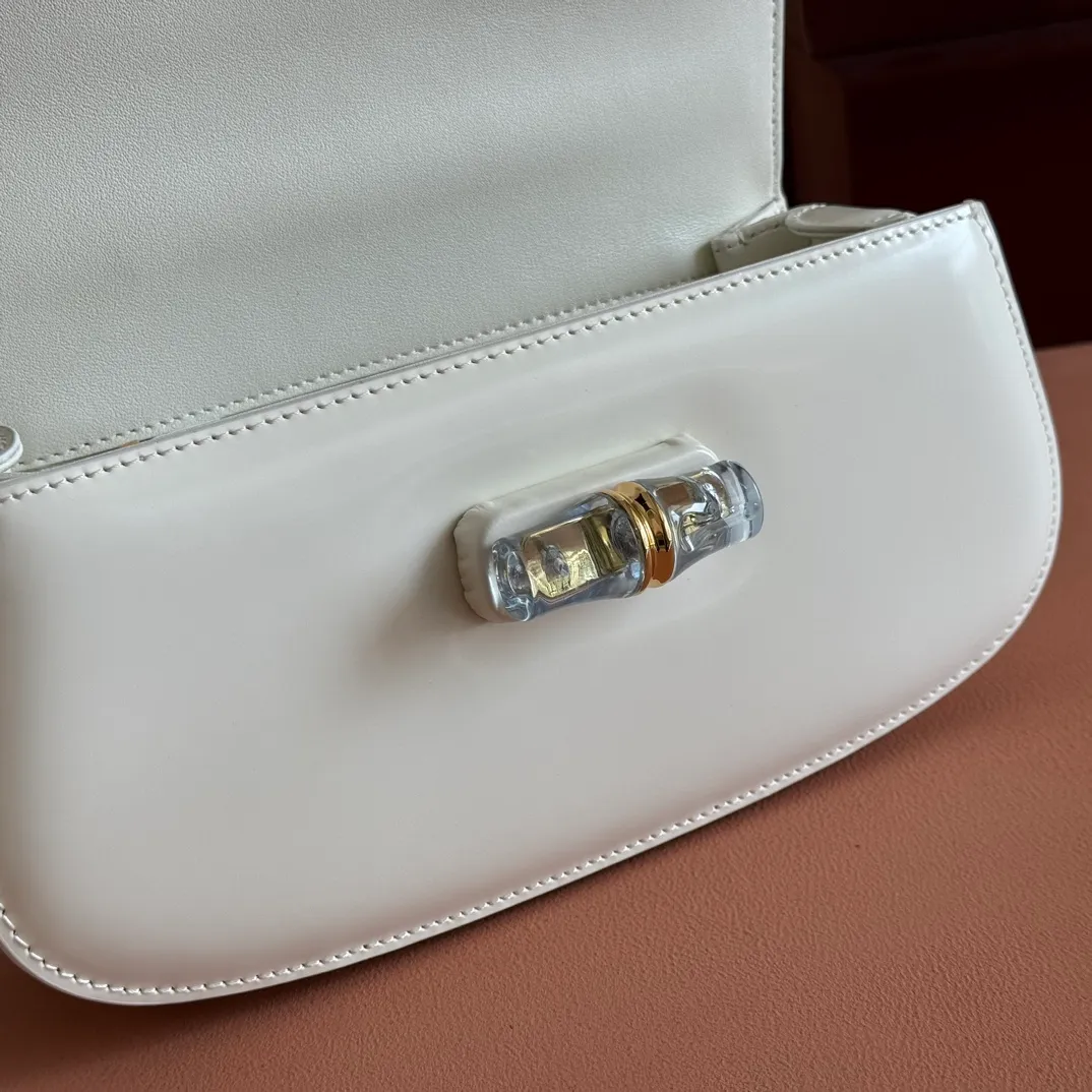 p1680. 💋💋💋 Equipped with full counter packaging [New Product] This small handbag reinterprets the iconic bamboo-shaped accessories with resin and brass details, adding another dazzling masterpiece to the 2025 spring and summer series. The Gucci Bamboo Diva tote adds a pop of color to any look. White glossy buffed leather Resin and brass bamboo hardware Three-level articulated compartments White leather lining Interior: One zippered pocket and a mirror with removable pocket Handle height 10cm Removable and adjustable leather shoulder strap (50cm high); length adjustable between 100cm and 116cm Bamboo lock Model number: 827750 Dimensions: 26.6cm (width) x 13cm (h) x 8 cm (depth) Weight: about 0.9 kg Color: white full leather/original leather. Made in Italy
