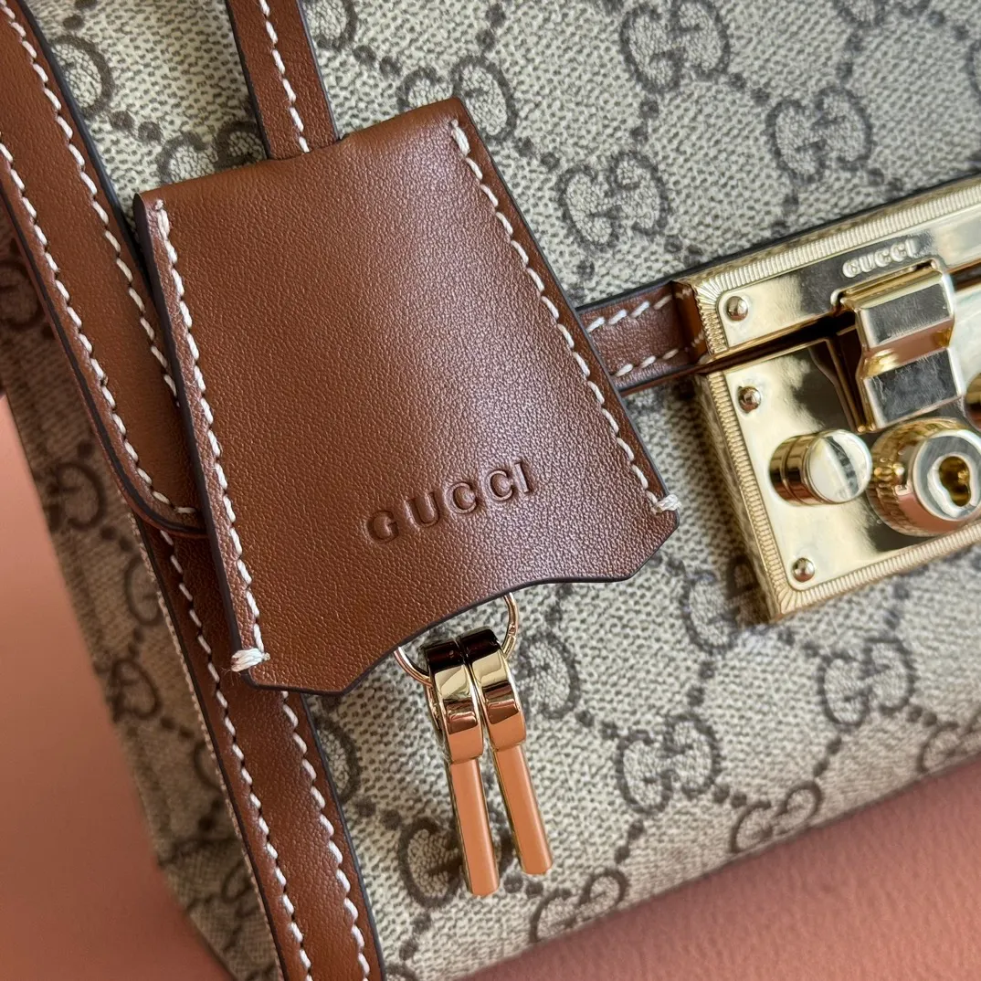 p1120. 💋💋💋"With full set of original counter packaging" [New product] Padlock series makes a stunning appearance in the 2025 early autumn series with modern silhouettes, unlocking multiple carrying methods. This style can be worn by hand or cross-body and has a web lining that pays homage to the brand's signature elements. Beige and dark brown GG monogram coated fabric Brown leather piping Light gold tone hardware Cotton lining with red and green webbing Interior: one open pocket External: one open pocket Carry handles (6 cm height) Removable and adjustable leather shoulder strap (height: 57 cm – 62 cm; length: 103 cm – 123 cm) Padlock clasp with leather keychain Ident No.: 838999. Dimensions: 20cm (width) x 13cm (height) x 8cm (depth) Weight: about 0.6kg Color: Brown/PVC.