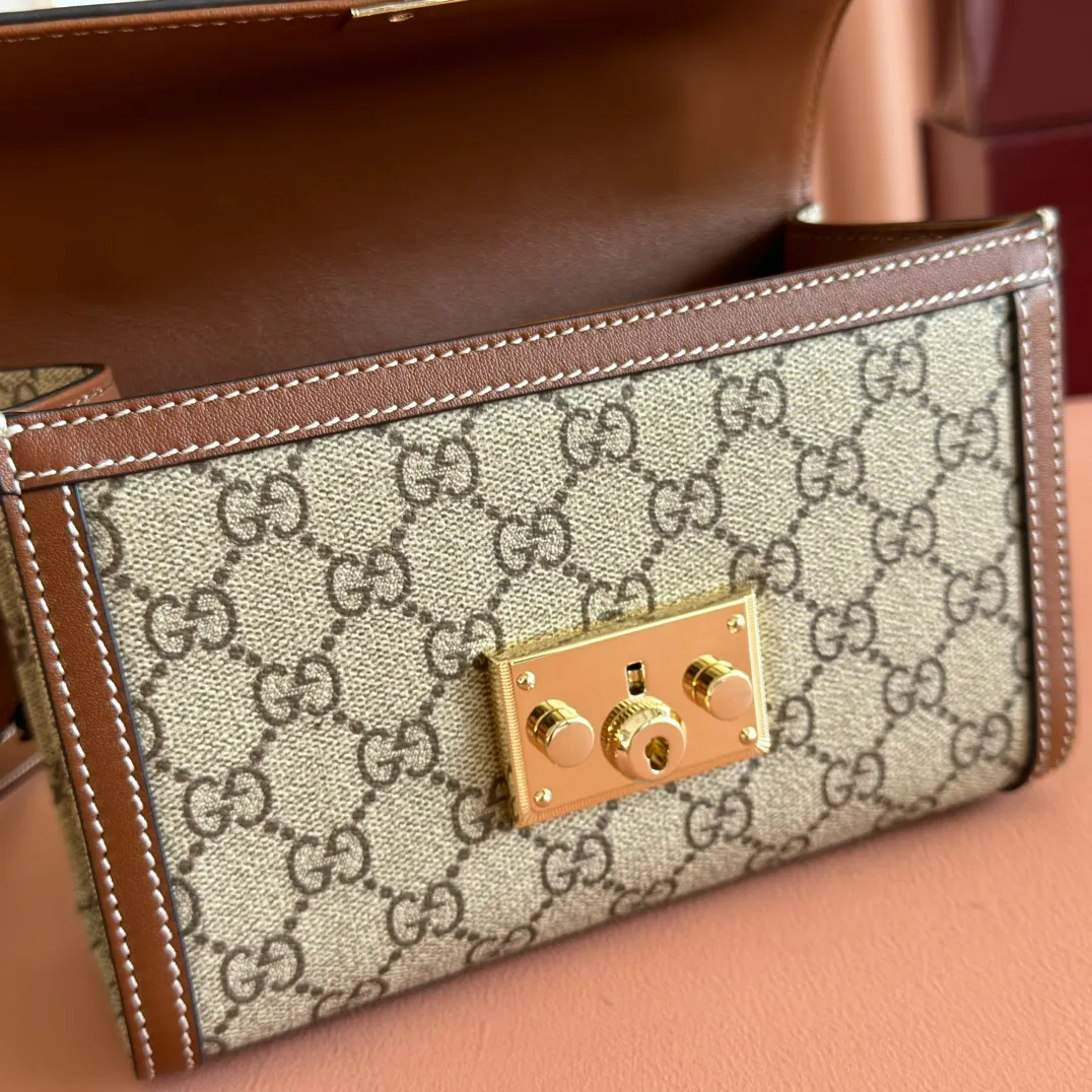 p1120. 💋💋💋"With full set of original counter packaging" [New product] Padlock series makes a stunning appearance in the 2025 early autumn series with modern silhouettes, unlocking multiple carrying methods. This style can be worn by hand or cross-body and has a web lining that pays homage to the brand's signature elements. Beige and dark brown GG monogram coated fabric Brown leather piping Light gold tone hardware Cotton lining with red and green webbing Interior: one open pocket External: one open pocket Carry handles (6 cm height) Removable and adjustable leather shoulder strap (height: 57 cm – 62 cm; length: 103 cm – 123 cm) Padlock clasp with leather keychain Ident No.: 838999. Dimensions: 20cm (width) x 13cm (height) x 8cm (depth) Weight: about 0.6kg Color: Brown/PVC.