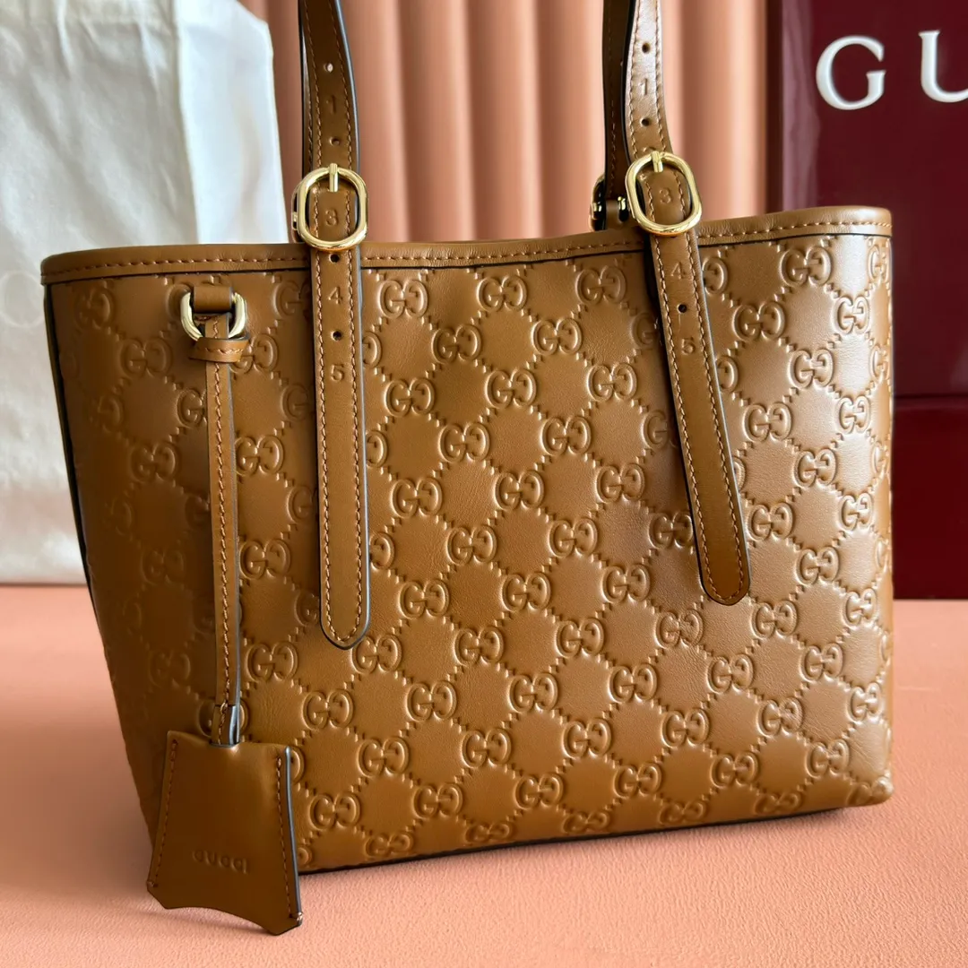 p1120. 💋💋💋"With full set of original counter packaging" [New Product] 2025 Autumn and Winter Series, the GG Emblem series reinterprets the brand's timeless elegance and exquisite craftsmanship. This tote bag features a tonal cotton-lined interior compartment and an adjustable shoulder strap for added functionality. Pink GG printed embossed leather Light gold tone hardware Light pink cotton lining The bag pictured is sold separately and does not come with the bag charm. Interior: Zippered pocket Adjustable leather shoulder strap: Height: 16 cm - 26 cm; Length: 72 cm Model number: 847456. Dimensions: 25cm (W) x 20cm (H) x 10cm (D) Weight: Approx. 0.55kg Color: Brown embossed. Made in Italy