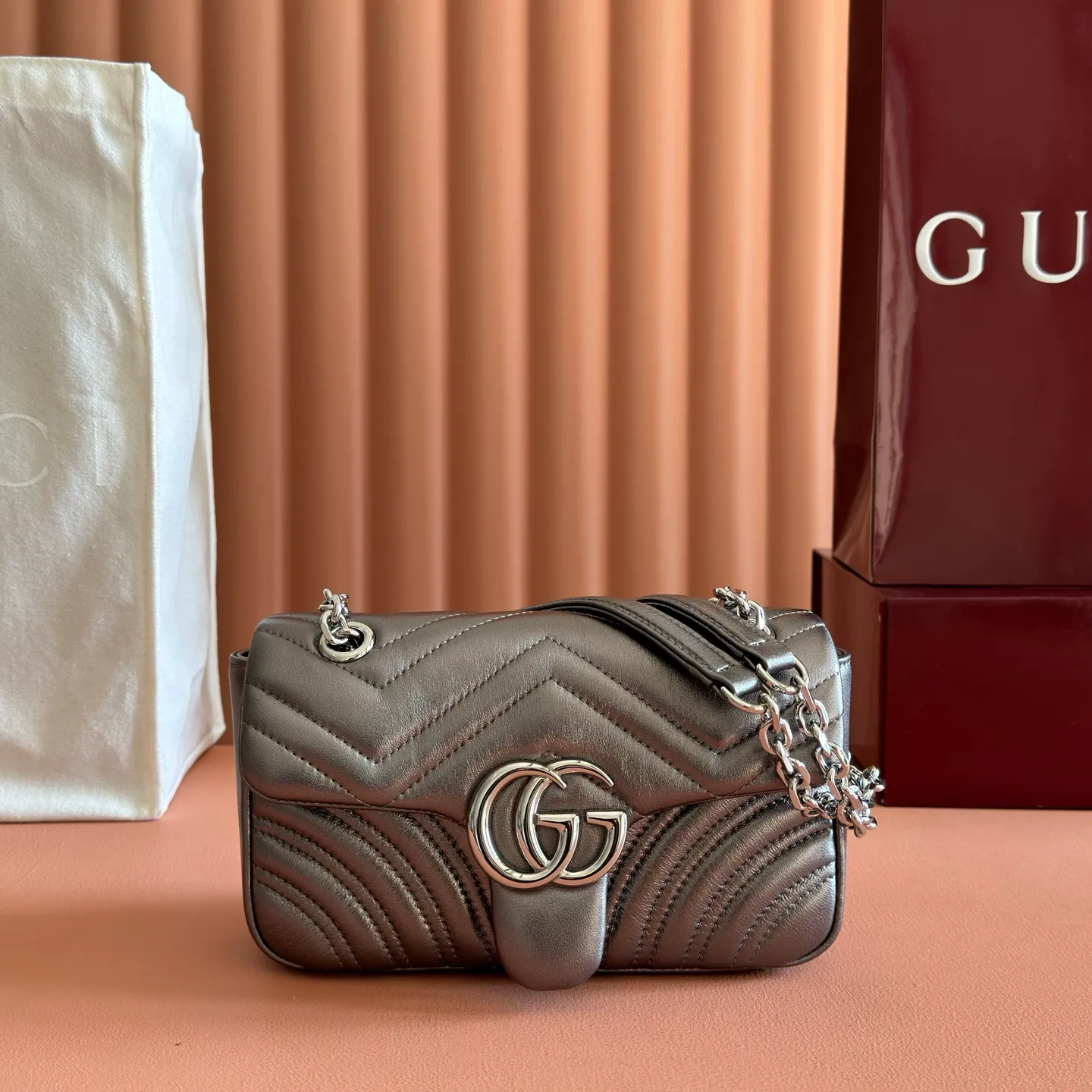p1120💋💋💋【With full set of original counter packaging】The brand's iconic GG Marmont series is ingeniously integrated with double G styling accessories, faceted chain straps and soft silhouettes, and is made of gold and silver thread leather to create a shoulder bag style. Silver metallic quilted V-shaped lamé leather Silver-toned hardware Silver viscose lining Double G Interior: One open pocket Sliding chain strap that can be used as a shoulder strap (55 cm high) Spring-buckle flap Ref.: 837280. Dimensions: 22cm (W) x 12.5cm (H) x 6cm (D) Weight: approx. 0.55kg Colour: Gunmetal sheepskin Made in Italy