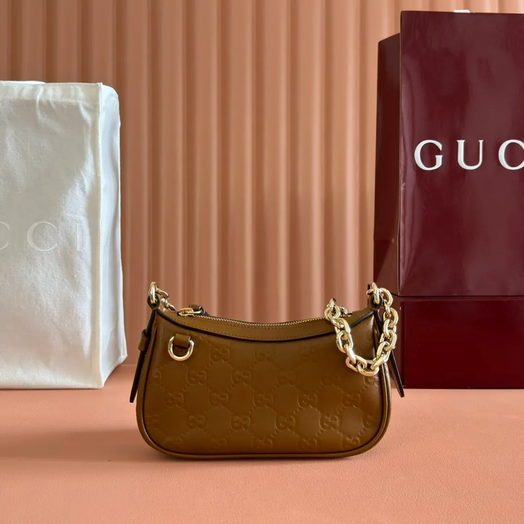 p900. 💋💋💋《With full set of original factory counter packaging》‼ ️【New Product】2025 Autumn and Winter Series, this small shoulder bag adopts a round silhouette with gold-tone accessories and chain straps, highlighting the style of the GG Emblem series. It features a zipper closure, an interior card pocket, and a cotton and linen lining for a refined feel. Gucci black (Rosso Ancora) GG printed embossed calf leather Gold tone accessories Gucci black (Rosso Ancora) cotton and linen lining The bag pictured is sold separately and does not come with the bag charm. Interior: card pocket, chain shoulder strap (23cm high), zipper closure. Model number: 847091. Dimensions: 19cm (bottom width) x 16.5cm (top width) 12cm (height) x 4cm (bottom depth) x 2.5cm (top depth) Weight: Approx. 0.211kg Color: Brown/Embossed. Made in Italy