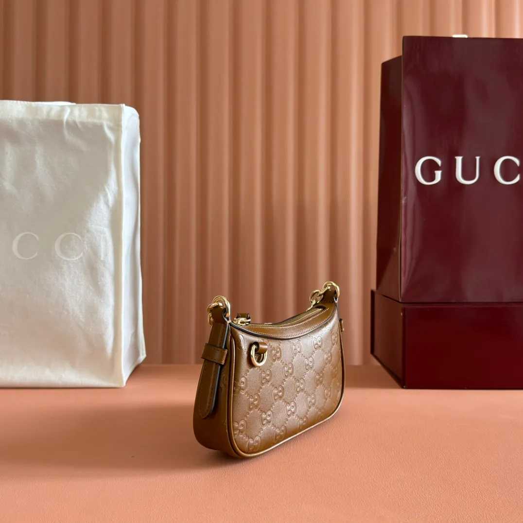 p900. 💋💋💋《With full set of original factory counter packaging》‼ ️【New Product】2025 Autumn and Winter Series, this small shoulder bag adopts a round silhouette with gold-tone accessories and chain straps, highlighting the style of the GG Emblem series. It features a zipper closure, an interior card pocket, and a cotton and linen lining for a refined feel. Gucci black (Rosso Ancora) GG printed embossed calf leather Gold tone accessories Gucci black (Rosso Ancora) cotton and linen lining The bag pictured is sold separately and does not come with the bag charm. Interior: card pocket, chain shoulder strap (23cm high), zipper closure. Model number: 847091. Dimensions: 19cm (bottom width) x 16.5cm (top width) 12cm (height) x 4cm (bottom depth) x 2.5cm (top depth) Weight: Approx. 0.211kg Color: Brown/Embossed. Made in Italy