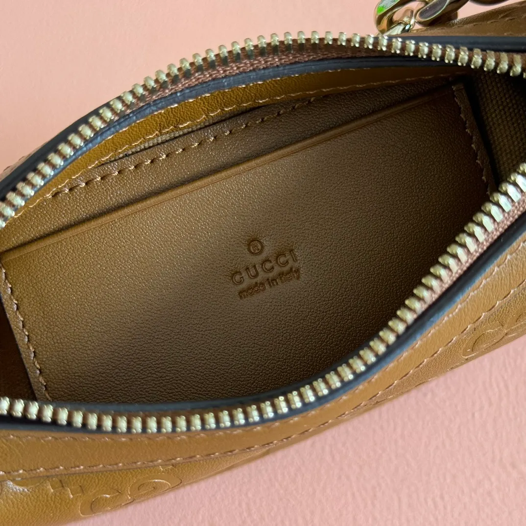 p900. 💋💋💋《With full set of original factory counter packaging》‼ ️【New Product】2025 Autumn and Winter Series, this small shoulder bag adopts a round silhouette with gold-tone accessories and chain straps, highlighting the style of the GG Emblem series. It features a zipper closure, an interior card pocket, and a cotton and linen lining for a refined feel. Gucci black (Rosso Ancora) GG printed embossed calf leather Gold tone accessories Gucci black (Rosso Ancora) cotton and linen lining The bag pictured is sold separately and does not come with the bag charm. Interior: card pocket, chain shoulder strap (23cm high), zipper closure. Model number: 847091. Dimensions: 19cm (bottom width) x 16.5cm (top width) 12cm (height) x 4cm (bottom depth) x 2.5cm (top depth) Weight: Approx. 0.211kg Color: Brown/Embossed. Made in Italy