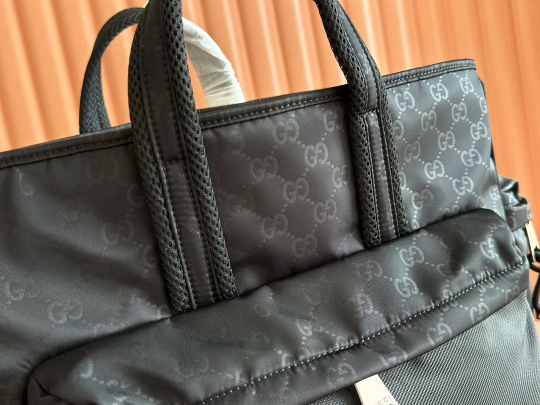 p1100💋💋💋【Equipped with counter gift bags】2025 early spring men's bag series, ingeniously blending fashionable lines and sporty style. This tote bag is crafted from soft and durable black nylon, with an all-over GG pattern to highlight its sophisticated undertones. Other classic details include red and green webbing details. Black GG nylon Nylon lining Web detail Interior: 1 zipped pocket External: 1 zipped front pocket, 1 zipped back pocket and 2 zipped side pockets Top handle height: 9cm Adjustable canvas shoulder strap (55cm high); length adjustable between 75cm and 132cm Model number: 818962. Dimensions: 38cm (width) x 40cm (height) x 23cm (depth) Weight: about 1.14kg Color: black nylon cloth/original leather. Made in Italy