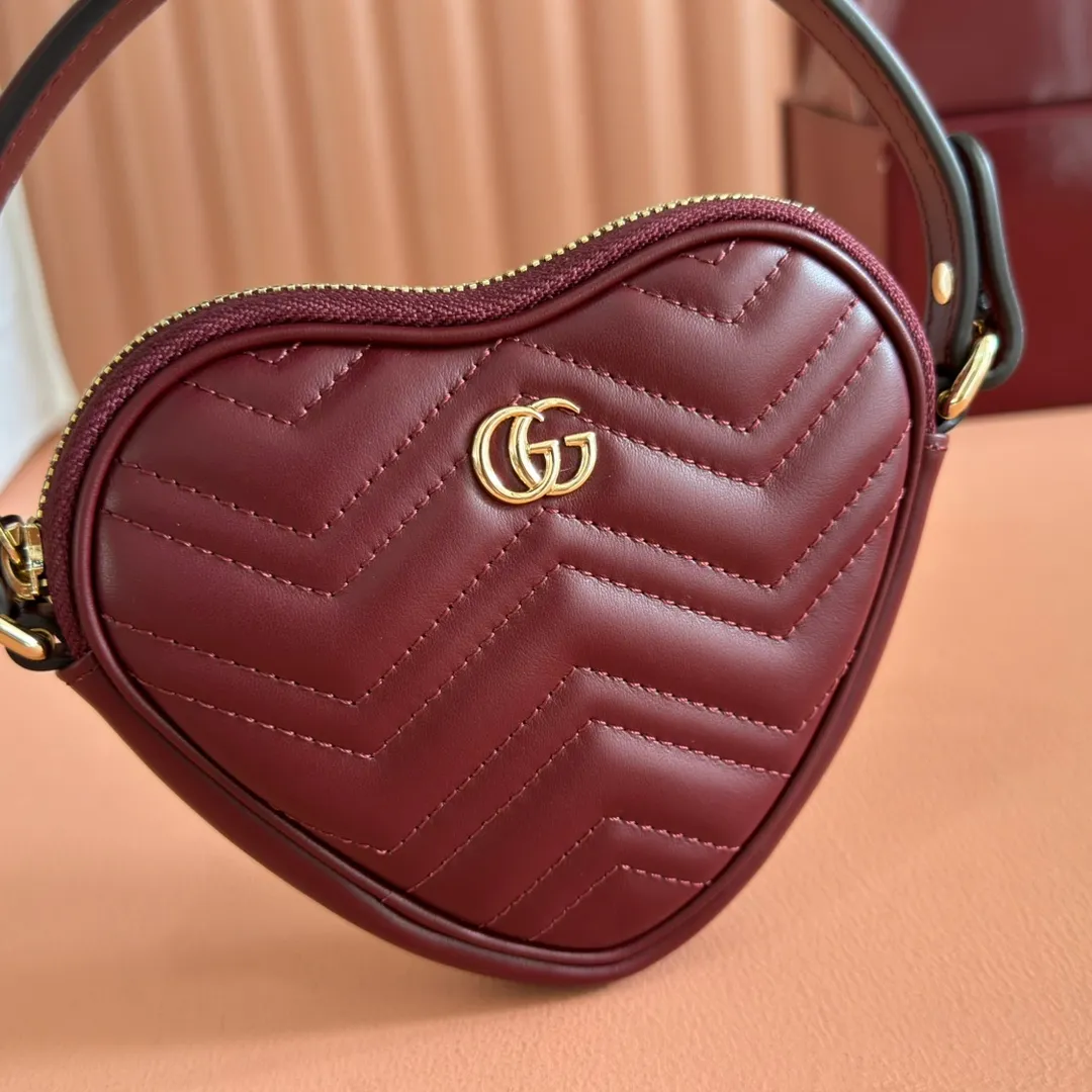 p940. 💋💋💋"With full set of original counter packaging" [New product] This GG Marmont series mini handbag has a playful and cute heart-shaped silhouette and is crafted from soft Gucci Ancola red V-shaped Matelassé cow leather. The bag has a simple and compact shape and is equipped with the iconic Double G accessories in light gold tones. Gucci Rosso Ancora red quilted V-shaped calfskin leather Light gold tone hardware Red taffeta lining Double G Interior: One card compartment Carry handle (8 cm height) Detachable and adjustable shoulder strap (48 cm height) Zip closure Weight: approx. 0.162 kg Ident number: 837753. Dimensions: 13.5cm (width) x 11.5cm (height) x 2.5cm (depth) Color: Red full leather. Made in Italy
