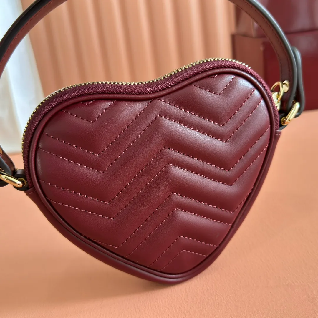 p940. 💋💋💋"With full set of original counter packaging" [New product] This GG Marmont series mini handbag has a playful and cute heart-shaped silhouette and is crafted from soft Gucci Ancola red V-shaped Matelassé cow leather. The bag has a simple and compact shape and is equipped with the iconic Double G accessories in light gold tones. Gucci Rosso Ancora red quilted V-shaped calfskin leather Light gold tone hardware Red taffeta lining Double G Interior: One card compartment Carry handle (8 cm height) Detachable and adjustable shoulder strap (48 cm height) Zip closure Weight: approx. 0.162 kg Ident number: 837753. Dimensions: 13.5cm (width) x 11.5cm (height) x 2.5cm (depth) Color: Red full leather. Made in Italy