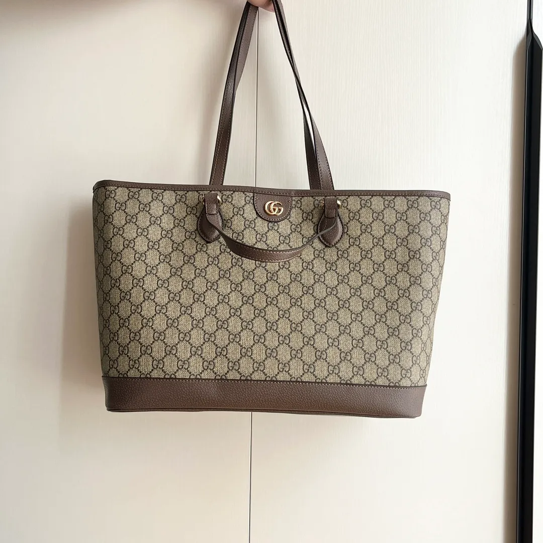 Actual shot #💰300 Model: 739730 Size: 38.5x28.5x15cm The GG Ophidia series is still one of Gucci’s iconic handbags. The brand launches new styles every season, creating versatile accessories that suit every look. Two handles give this tote a multi-functional character, allowing it to be worn as a shoulder bag or as a handbag. As a classic design element, the Double G has been deeply embedded in the brand's design. On this handbag, it is presented in a dazzling manner, contrasting with the GG Supreme canvas and brown leather piping.