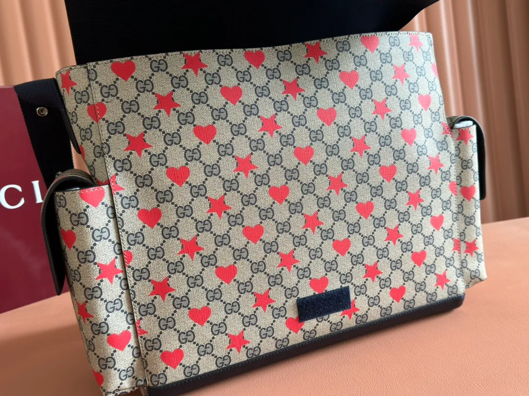 p1140. 💋💋💋"With full set of original counter gift bag packaging" [New Product] The children’s Cruise 2025 series presents a series of well-loved themes, including iconic logo details. Made from GG Supreme canvas, this diaper bag displays an all-over star and heart print and features dark blue bands. Beige and blue GG Supreme canvas. Dark blue ribbon decoration. All-over star and heart print. Washable nylon lining. Interior: 3 stretchy open pockets, 2 stretchy water bottles. Model: 811491. Size: 45x32x15cm Color: star dark blue/pvc. Made in Italy