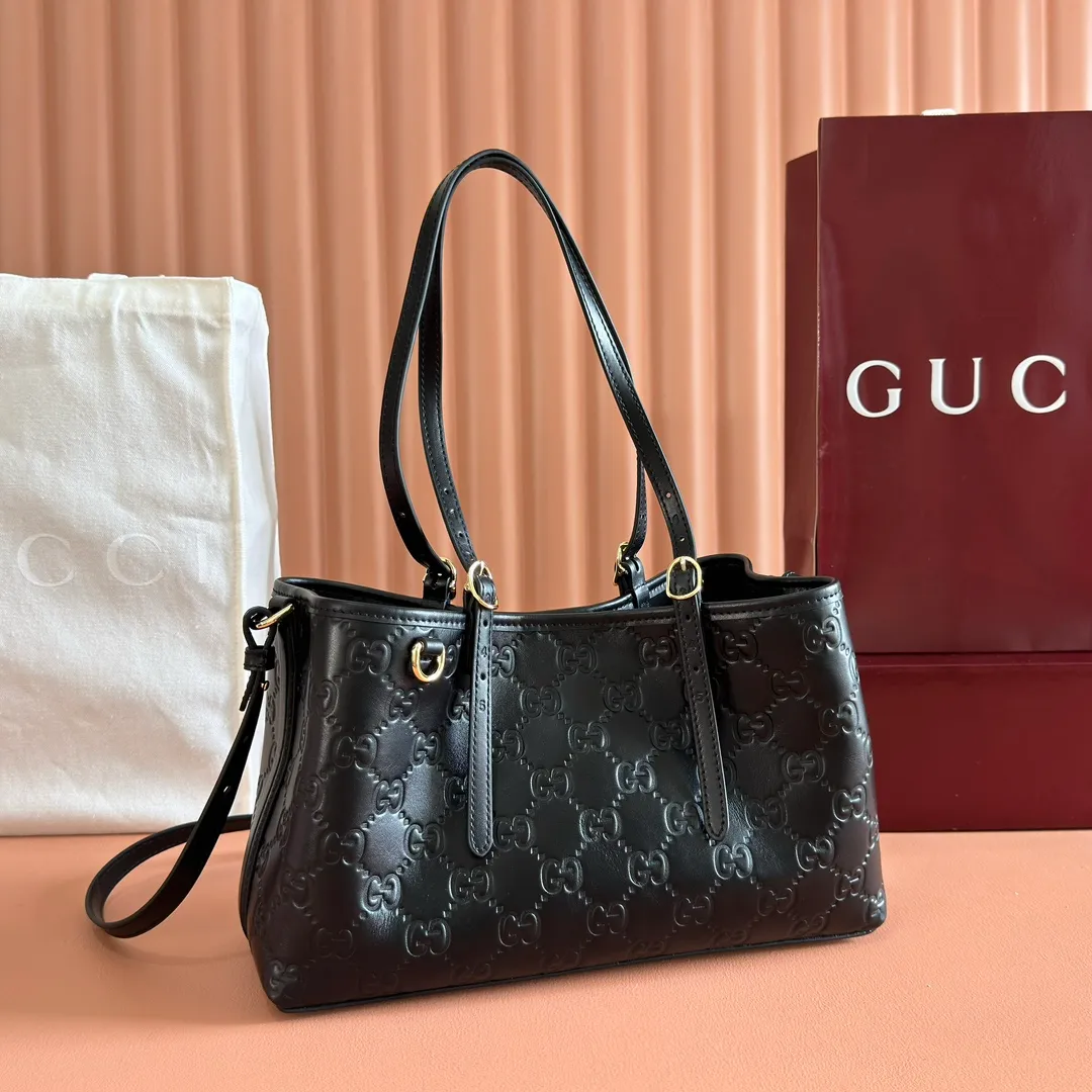 p1400. 💋💋💋Original leather configuration with full counter packaging [New product] GG Emblem series reinterprets the brand's timeless elegance and exquisite craftsmanship. Crafted in light pink, this small tote bag features adjustable handles with eyelets for an elegant look inspired by the equestrian world. Black GG Monogram coated fabric Black leather trim Light gold tone hardware Webbing cotton lining Additional D-ring for hanging removable items Adjustable handle with numbered eyelets; Height 18cm - 28cm Interior: 2 compartments and 1 central zippered compartment Adjustable leather shoulder strap (H 51.5cm - 57cm); length adjustable between 104cm and 114cm Magnetic snap closure Model: 815214. Dimensions: 30cm (width) x 18cm (height) x 11cm (depth) Weight: approx. 0.8kg Color: black pressed/original leather. Made in Italy