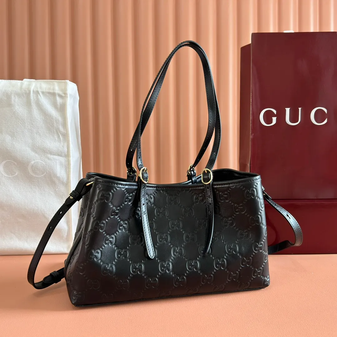 p1400. 💋💋💋Original leather configuration with full counter packaging [New product] GG Emblem series reinterprets the brand's timeless elegance and exquisite craftsmanship. Crafted in light pink, this small tote bag features adjustable handles with eyelets for an elegant look inspired by the equestrian world. Black GG Monogram coated fabric Black leather trim Light gold tone hardware Webbing cotton lining Additional D-ring for hanging removable items Adjustable handle with numbered eyelets; Height 18cm - 28cm Interior: 2 compartments and 1 central zippered compartment Adjustable leather shoulder strap (H 51.5cm - 57cm); length adjustable between 104cm and 114cm Magnetic snap closure Model: 815214. Dimensions: 30cm (width) x 18cm (height) x 11cm (depth) Weight: approx. 0.8kg Color: black pressed/original leather. Made in Italy