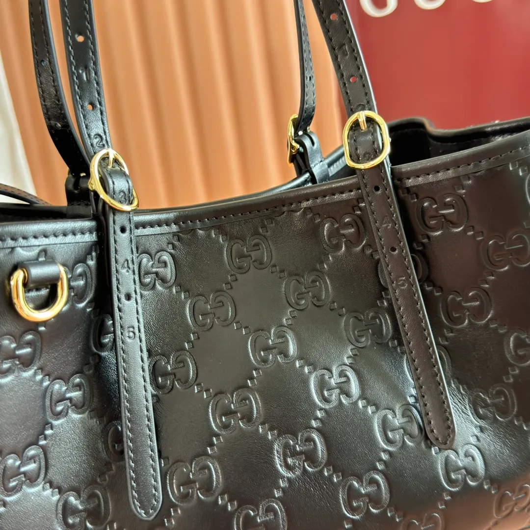 p1400. 💋💋💋Original leather configuration with full counter packaging [New product] GG Emblem series reinterprets the brand's timeless elegance and exquisite craftsmanship. Crafted in light pink, this small tote bag features adjustable handles with eyelets for an elegant look inspired by the equestrian world. Black GG Monogram coated fabric Black leather trim Light gold tone hardware Webbing cotton lining Additional D-ring for hanging removable items Adjustable handle with numbered eyelets; Height 18cm - 28cm Interior: 2 compartments and 1 central zippered compartment Adjustable leather shoulder strap (H 51.5cm - 57cm); length adjustable between 104cm and 114cm Magnetic snap closure Model: 815214. Dimensions: 30cm (width) x 18cm (height) x 11cm (depth) Weight: approx. 0.8kg Color: black pressed/original leather. Made in Italy