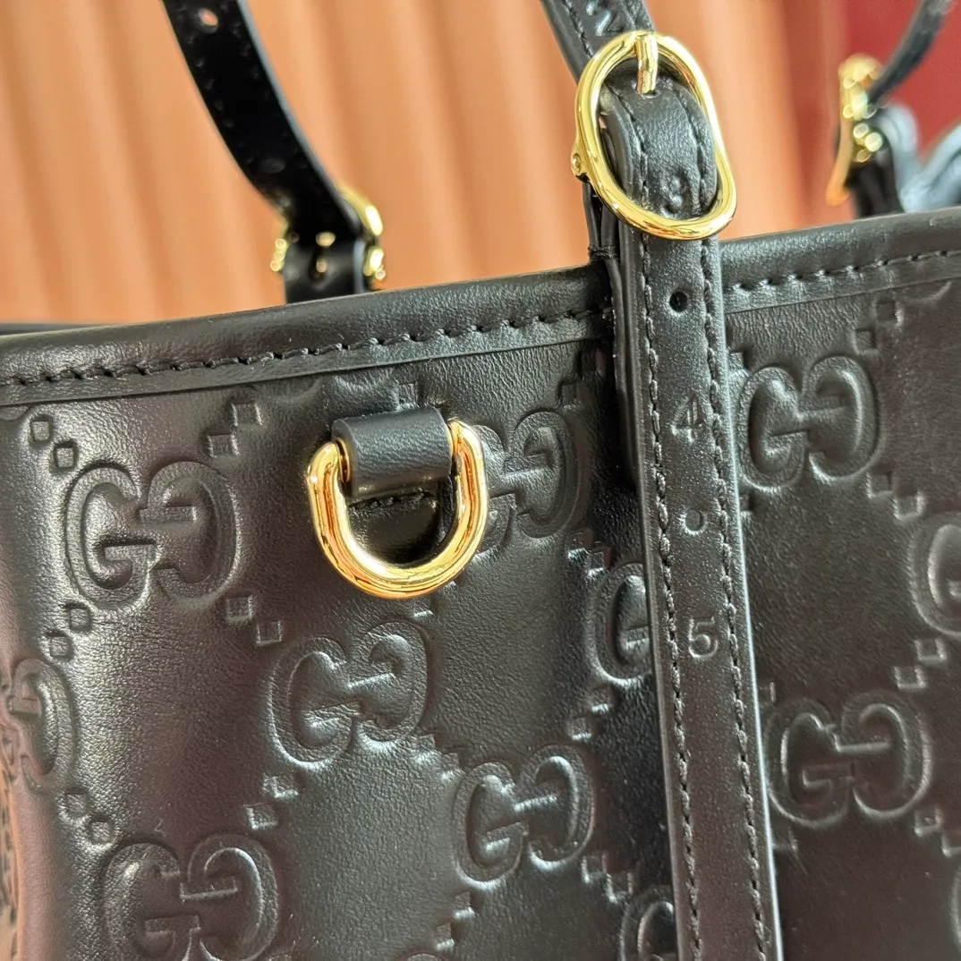 p1400. 💋💋💋Original leather configuration with full counter packaging [New product] GG Emblem series reinterprets the brand's timeless elegance and exquisite craftsmanship. Crafted in light pink, this small tote bag features adjustable handles with eyelets for an elegant look inspired by the equestrian world. Black GG Monogram coated fabric Black leather trim Light gold tone hardware Webbing cotton lining Additional D-ring for hanging removable items Adjustable handle with numbered eyelets; Height 18cm - 28cm Interior: 2 compartments and 1 central zippered compartment Adjustable leather shoulder strap (H 51.5cm - 57cm); length adjustable between 104cm and 114cm Magnetic snap closure Model: 815214. Dimensions: 30cm (width) x 18cm (height) x 11cm (depth) Weight: approx. 0.8kg Color: black pressed/original leather. Made in Italy