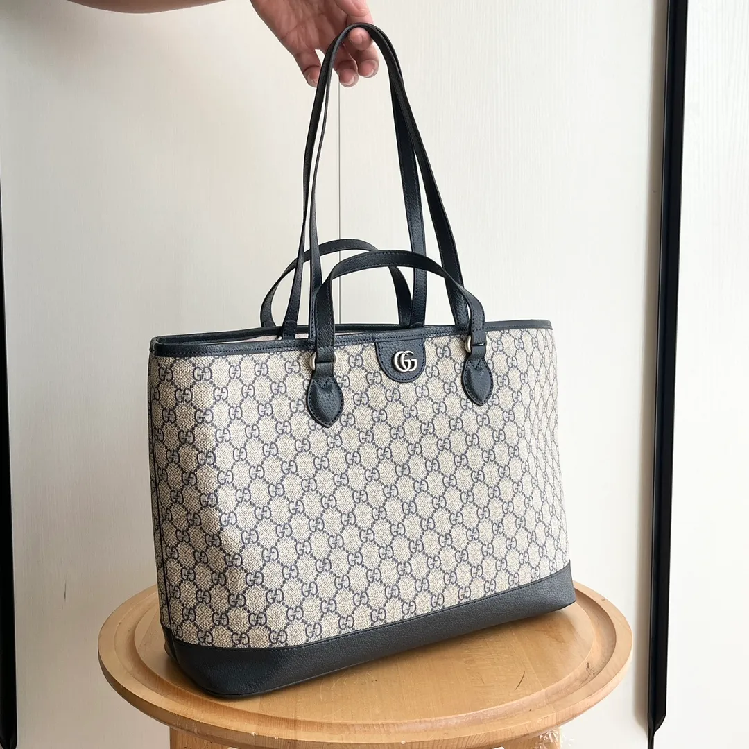 Actual shot #💰300 Model: 739730 Size: 38.5x28.5x15cm The GG Ophidia series is still one of Gucci’s iconic handbags. The brand launches new styles every season, creating versatile accessories that suit every look. Two handles give this tote a multi-functional character, allowing it to be worn as a shoulder bag or as a handbag. As a classic design element, the Double G has been deeply embedded in the brand's design. On this handbag, it is presented in a dazzling manner, contrasting with the GG Supreme canvas and brown leather piping.