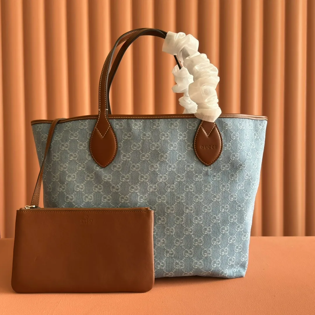 Pre-order 💋💋💋【Equipped with counter gift bag】The Gucci Totissima series combines the word "tote" with the superlative word "issima" in Italian, highlighting the practical function and timeless background of this handbag. This medium tote bag comes with a removable clutch. Blue GG denim Brown leather trim with contrasting stitching Blue cotton and linen lining Detachable clutch: 21.5 cm (W) x 12.5 cm (H) Top handle (21 cm H) Model: 820481. Dimensions: 30.5cm (width) x 28cm (height) x 27cm (depth) Color: Gray denim/original leather. Weight: approx. 0.6kg Made in Italy