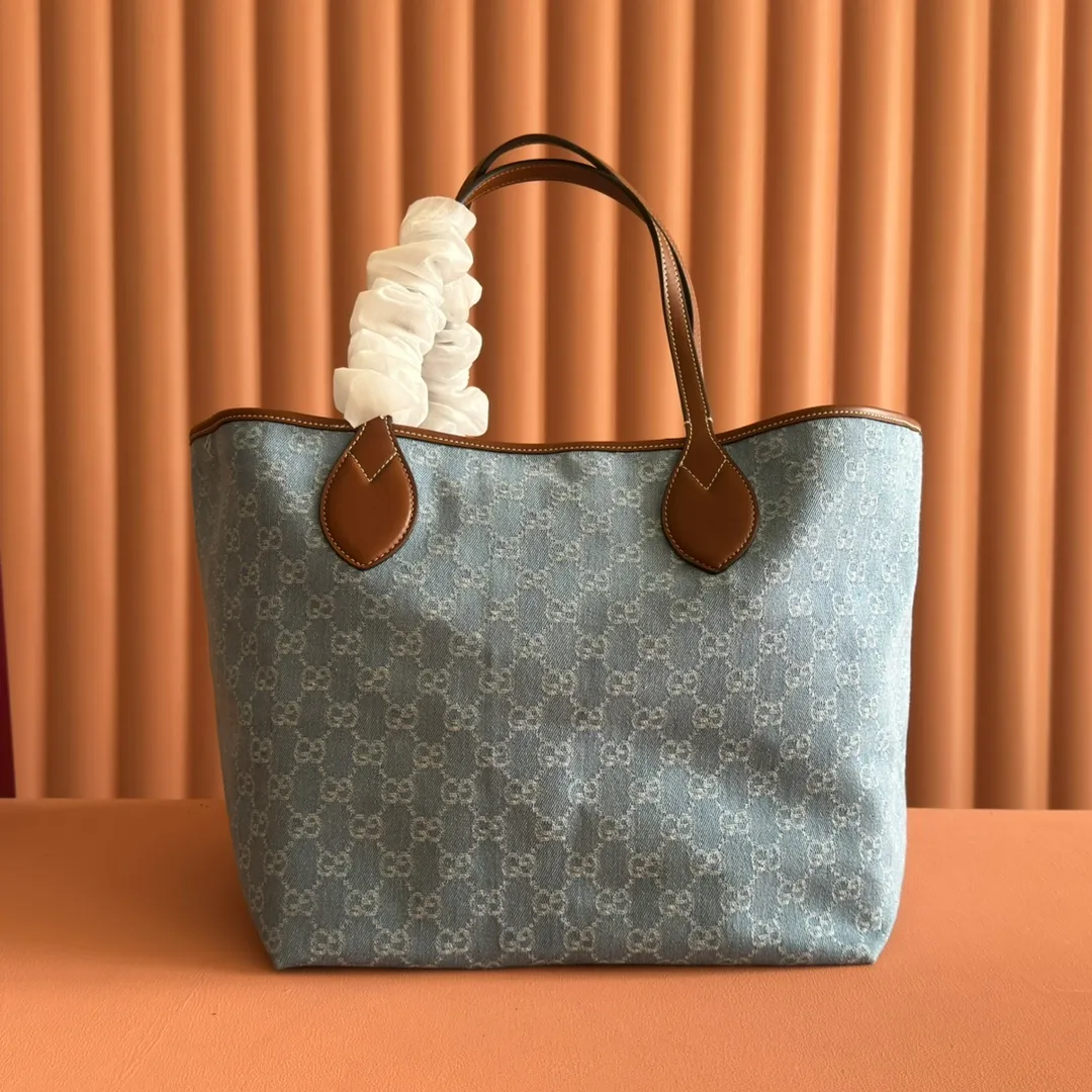 Pre-order 💋💋💋【Equipped with counter gift bag】The Gucci Totissima series combines the word "tote" with the superlative word "issima" in Italian, highlighting the practical function and timeless background of this handbag. This medium tote bag comes with a removable clutch. Blue GG denim Brown leather trim with contrasting stitching Blue cotton and linen lining Detachable clutch: 21.5 cm (W) x 12.5 cm (H) Top handle (21 cm H) Model: 820481. Dimensions: 30.5cm (width) x 28cm (height) x 27cm (depth) Color: Gray denim/original leather. Weight: approx. 0.6kg Made in Italy