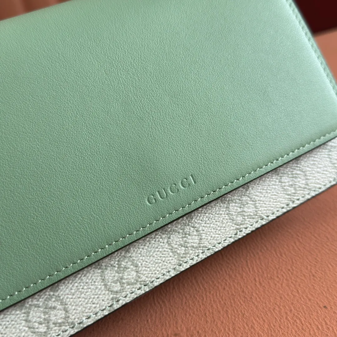 p640. Equipped with a full set of packaging at the counter [New Product] The GG Emblem series reinterprets the brand's timeless elegance and exquisite craftsmanship. This sage-green chain wallet is crafted from leather and GG monogram coated fabric and features a chain strap. Grey-green glossy leather Grey-green GG Supreme canvas Gucci print embossed details Taffeta lining Interior: 6 card compartments, 2 flat pockets, 1 zipped pocket Chain shoulder strap (52 cm high) Ident.: 826720. Dimensions: 20 cm (width) x 13 cm (height) x 4 cm (depth) Weight: about 413 grams Color: green gray pvc/original leather. Made in Italy