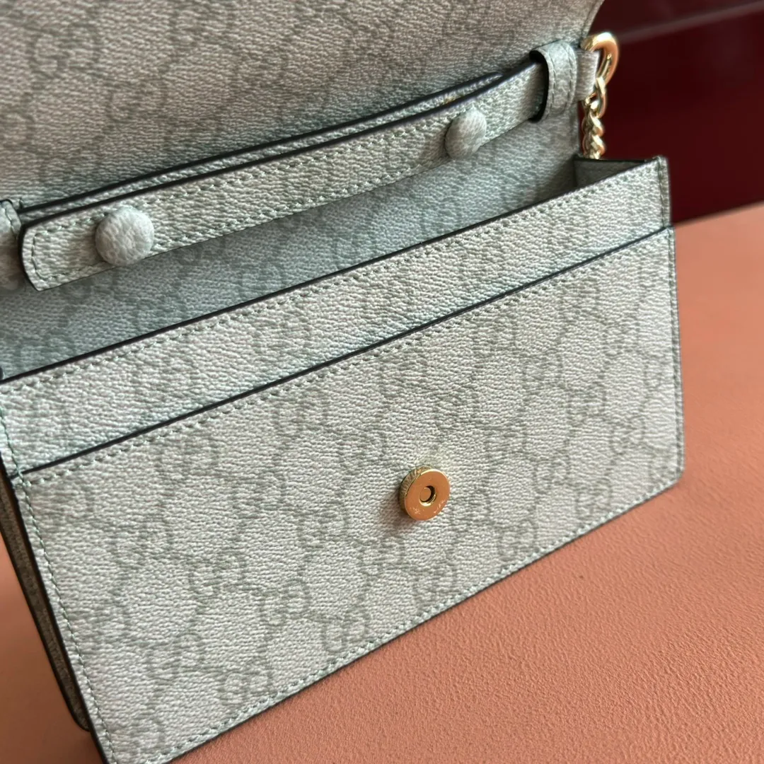 p640. Equipped with a full set of packaging at the counter [New Product] The GG Emblem series reinterprets the brand's timeless elegance and exquisite craftsmanship. This sage-green chain wallet is crafted from leather and GG monogram coated fabric and features a chain strap. Grey-green glossy leather Grey-green GG Supreme canvas Gucci print embossed details Taffeta lining Interior: 6 card compartments, 2 flat pockets, 1 zipped pocket Chain shoulder strap (52 cm high) Ident.: 826720. Dimensions: 20 cm (width) x 13 cm (height) x 4 cm (depth) Weight: about 413 grams Color: green gray pvc/original leather. Made in Italy