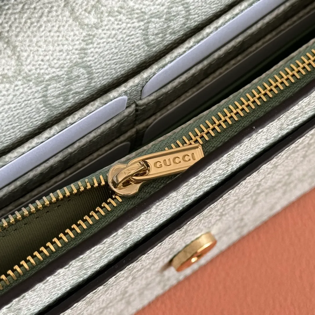 p640. Equipped with a full set of packaging at the counter [New Product] The GG Emblem series reinterprets the brand's timeless elegance and exquisite craftsmanship. This sage-green chain wallet is crafted from leather and GG monogram coated fabric and features a chain strap. Grey-green glossy leather Grey-green GG Supreme canvas Gucci print embossed details Taffeta lining Interior: 6 card compartments, 2 flat pockets, 1 zipped pocket Chain shoulder strap (52 cm high) Ident.: 826720. Dimensions: 20 cm (width) x 13 cm (height) x 4 cm (depth) Weight: about 413 grams Color: green gray pvc/original leather. Made in Italy
