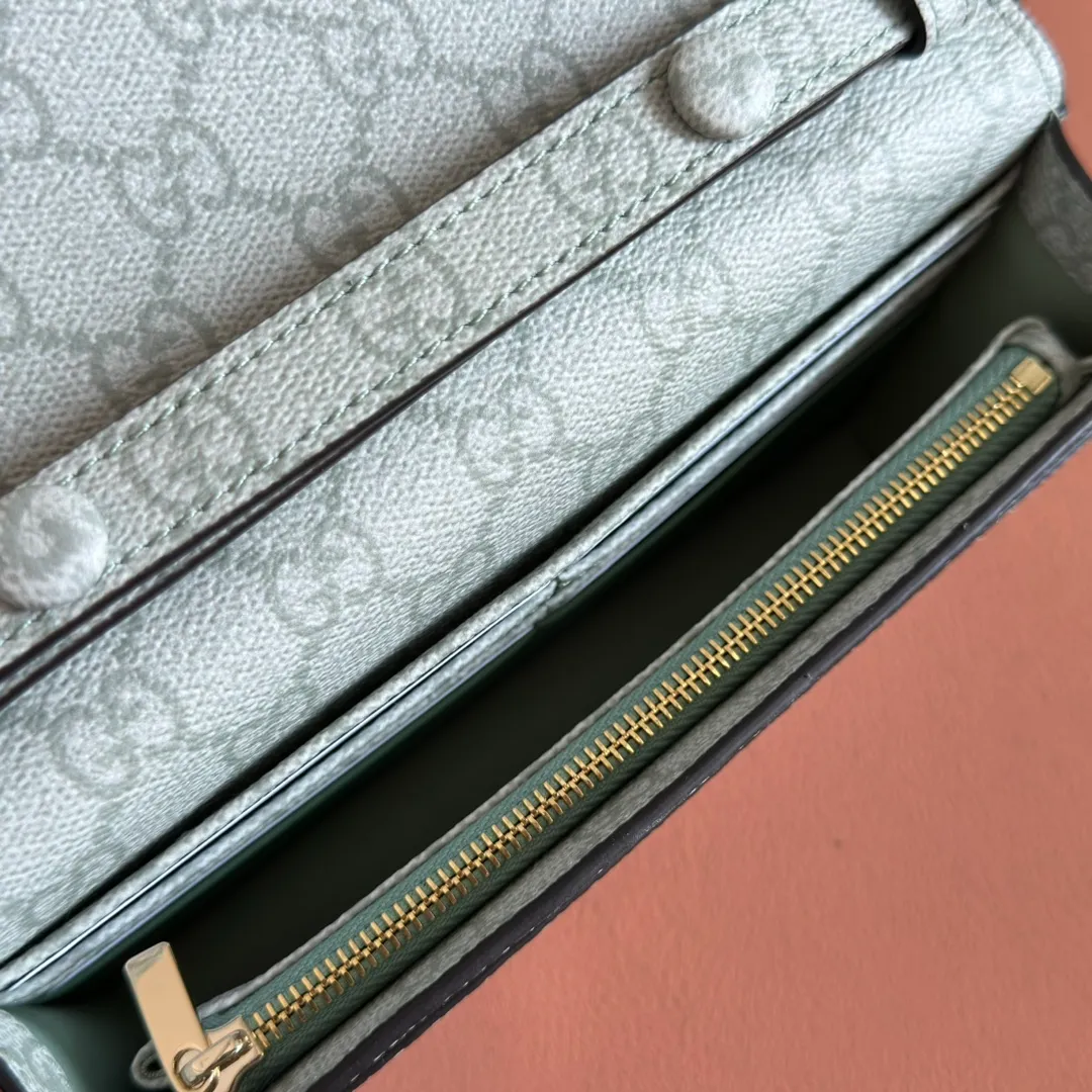 p640. Equipped with a full set of packaging at the counter [New Product] The GG Emblem series reinterprets the brand's timeless elegance and exquisite craftsmanship. This sage-green chain wallet is crafted from leather and GG monogram coated fabric and features a chain strap. Grey-green glossy leather Grey-green GG Supreme canvas Gucci print embossed details Taffeta lining Interior: 6 card compartments, 2 flat pockets, 1 zipped pocket Chain shoulder strap (52 cm high) Ident.: 826720. Dimensions: 20 cm (width) x 13 cm (height) x 4 cm (depth) Weight: about 413 grams Color: green gray pvc/original leather. Made in Italy
