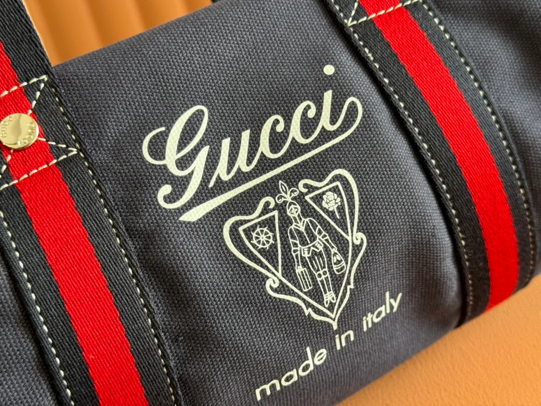 p960. 💋💋💋"With full set of original counter packaging"💕[New Product] With the theme of freedom, vitality and community, the 2025 spring and summer series newly presents a variety of travel items and men's bags, adding more fun to travel and exploration. This canvas travel bag features embellished stitching at the top, blue leather piping and a 'Gucci Made in Italy' badge printed on the front. Dark blue canvas Dark blue leather trimming "Gucci Made in Italy" and badge print Red and green webbing Top stitching detail Interior: 1 side handle Handle height: 12.5cm Adjustable webbing and canvas shoulder strap (55cm height); length adjustable from 77cm to 136cm Zip closure Ident.: 816865. Dimensions: 30cm (W) x 16cm (H) x 15cm (D) Weight: Approx. 0.54kg Color: Dark blue canvas. Made in Italy