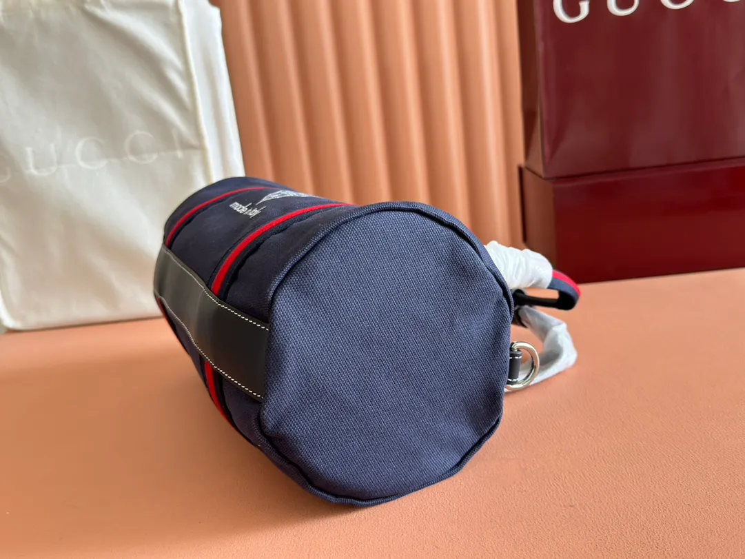 p960. 💋💋💋"With full set of original counter packaging"💕[New Product] With the theme of freedom, vitality and community, the 2025 spring and summer series newly presents a variety of travel items and men's bags, adding more fun to travel and exploration. This canvas travel bag features embellished stitching at the top, blue leather piping and a 'Gucci Made in Italy' badge printed on the front. Dark blue canvas Dark blue leather trimming "Gucci Made in Italy" and badge print Red and green webbing Top stitching detail Interior: 1 side handle Handle height: 12.5cm Adjustable webbing and canvas shoulder strap (55cm height); length adjustable from 77cm to 136cm Zip closure Ident.: 816865. Dimensions: 30cm (W) x 16cm (H) x 15cm (D) Weight: Approx. 0.54kg Color: Dark blue canvas. Made in Italy