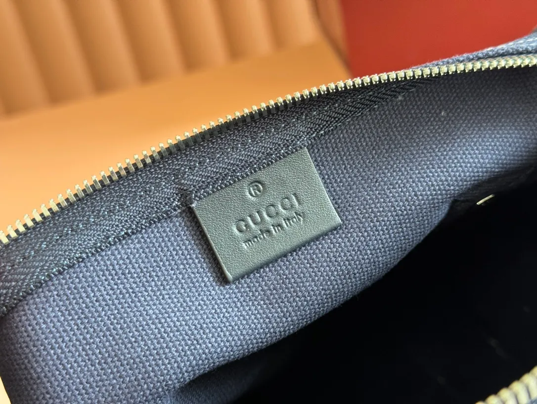 p960. 💋💋💋"With full set of original counter packaging"💕[New Product] With the theme of freedom, vitality and community, the 2025 spring and summer series newly presents a variety of travel items and men's bags, adding more fun to travel and exploration. This canvas travel bag features embellished stitching at the top, blue leather piping and a 'Gucci Made in Italy' badge printed on the front. Dark blue canvas Dark blue leather trimming "Gucci Made in Italy" and badge print Red and green webbing Top stitching detail Interior: 1 side handle Handle height: 12.5cm Adjustable webbing and canvas shoulder strap (55cm height); length adjustable from 77cm to 136cm Zip closure Ident.: 816865. Dimensions: 30cm (W) x 16cm (H) x 15cm (D) Weight: Approx. 0.54kg Color: Dark blue canvas. Made in Italy