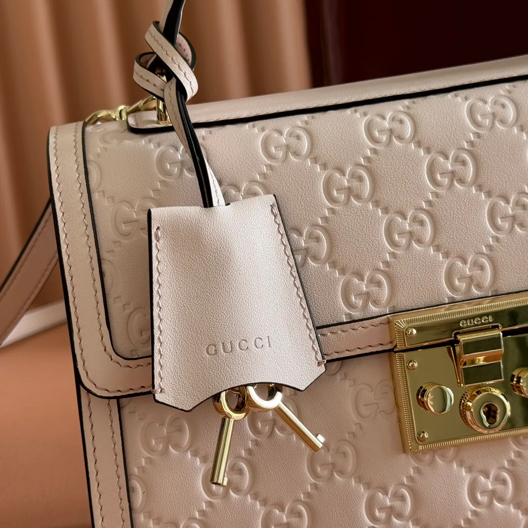 p1380. 💋💋💋 Comes with a full set of original counter packaging [New product] The Padlock series makes a stunning appearance in the 2025 autumn and winter series with fashionable silhouettes, unlocking a variety of carrying methods. This handbag is crafted from GG printed embossed cow leather. Light pink GG printed embossed calfskin Light gold tone hardware Light pink cotton lining Interior: 1 zipped pocket Exterior: 1 open pocket Handle height 7.9 cm Removable and adjustable calfskin shoulder strap (height: 54cm – 60cm; length: 114cm – 125cm) Padlock closure with calfskin keychain Ref.: 838998. Dimensions: 26cm (width) x 18cm (height) x 11.5cm (depth) Weight: approx. 0.8kg