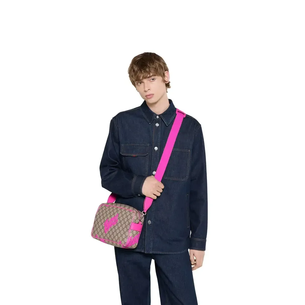 🔥In the 4050 early autumn series, Chinese artist Currynew reinterprets the brand logo, adding color to men's ready-to-wear, leather goods and accessories. This cross-body bag is crafted from coated fabric with the classic GG monogram pattern, cleverly integrated with Gucci prints and contrasting leather piping, making the entire design fuller. Beige and dark brown coated fabric with classic GG monogram pattern Bright pink leather trim Gucci print Currynew workmanship Cotton and linen blend lining Interior: 1 zip pocket Holds iPhone Plus, bi-fold wallet or card holder, and Airpods Removable canvas and leather shoulder strap (55cm high) Zip closure Ident No.: 839380. Dimensions: 27 cm (width) x 18 cm (height) x 7.5 cm (depth) Weight: about 0.61 kg Color: Purple silk screen/original leather.  Made in Italy
