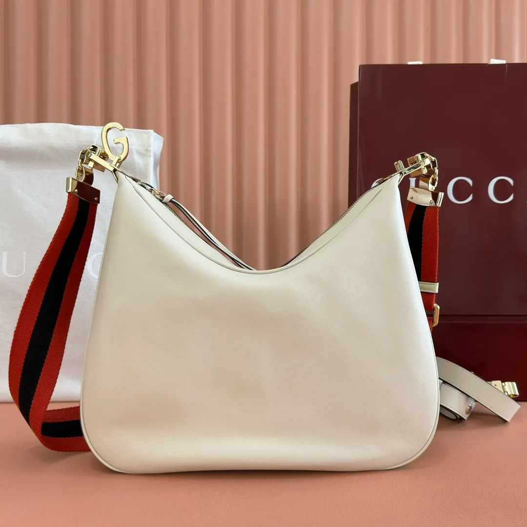 p1660. 📣📣📣【Original leather accessories🌈(equipped with full counter packaging)🔥🔥702823Gucci The Attache large shoulder bag "Gucci March of Love" is a new interpretation of the brand's archive elements, paying tribute to the enduring charm of Hollywood. This accessory features a recognizable crescent shape, and the G hook buckle adds a unique design aesthetic. The classic accessories are combined with soft materials to express retro charm. This large shoulder bag is made of beige and blue GG Supreme canvas, decorated with red and blue webbing. Hide details Beige and blue GG Supreme canvas with red and blue webbing. Gold-tone hardware Cotton and linen lining Additional leather shoulder strap Interior: 1 zipped pocket Removable webbing shoulder strap (50cm high) G-hook fastening with zip 35cm (W) x 32cm (H) x 6cm (D) Made in Italy