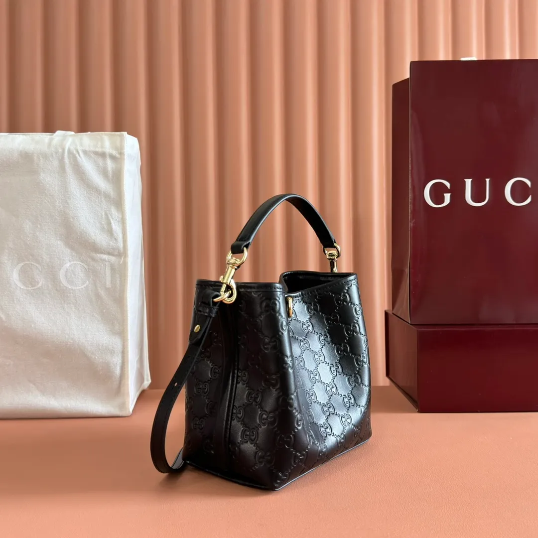 p1140. 💋💋💋Original leather configuration with full counter packaging [New product] GG Emblem series reinterprets the brand's timeless elegance and exquisite craftsmanship. Lined in webbed cotton, this bucket bag features an internal compartment for added functionality. Black GG printed embossed leather Light gold tone hardware Black cotton and linen blend lining Top handle with hook closure (height: 14cm) Additional D-ring for attaching removable items Interior: two compartments and a central snap-stud compartment Detachable and adjustable leather shoulder strap (height: 52cm - 57.5cm; length: 107cm - 114cm) Magnetic snap closure Ident No.: 815118. Dimensions: 19cm (width) x 18cm (height) x 11cm (depth) Weight: approx. 0.45kg Color: black embossed/original leather. Made in Italy