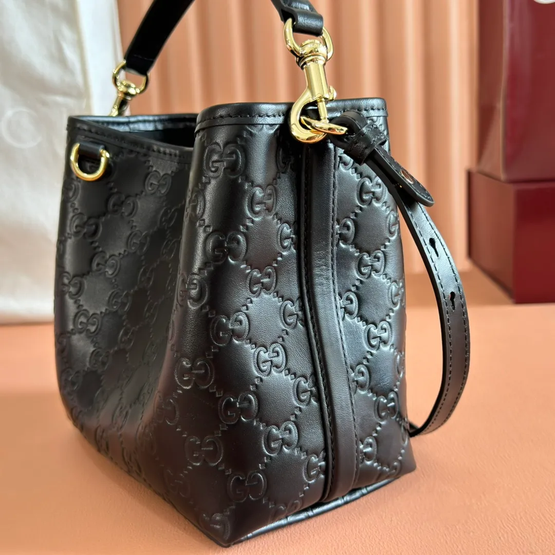 p1140. 💋💋💋Original leather configuration with full counter packaging [New product] GG Emblem series reinterprets the brand's timeless elegance and exquisite craftsmanship. Lined in webbed cotton, this bucket bag features an internal compartment for added functionality. Black GG printed embossed leather Light gold tone hardware Black cotton and linen blend lining Top handle with hook closure (height: 14cm) Additional D-ring for attaching removable items Interior: two compartments and a central snap-stud compartment Detachable and adjustable leather shoulder strap (height: 52cm - 57.5cm; length: 107cm - 114cm) Magnetic snap closure Ident No.: 815118. Dimensions: 19cm (width) x 18cm (height) x 11cm (depth) Weight: approx. 0.45kg Color: black embossed/original leather. Made in Italy