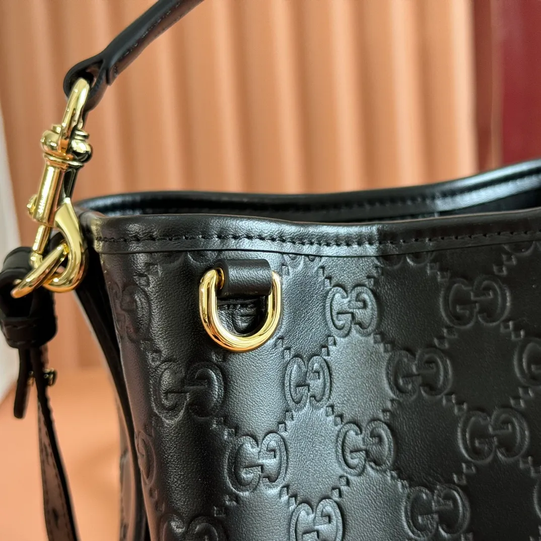 p1140. 💋💋💋Original leather configuration with full counter packaging [New product] GG Emblem series reinterprets the brand's timeless elegance and exquisite craftsmanship. Lined in webbed cotton, this bucket bag features an internal compartment for added functionality. Black GG printed embossed leather Light gold tone hardware Black cotton and linen blend lining Top handle with hook closure (height: 14cm) Additional D-ring for attaching removable items Interior: two compartments and a central snap-stud compartment Detachable and adjustable leather shoulder strap (height: 52cm - 57.5cm; length: 107cm - 114cm) Magnetic snap closure Ident No.: 815118. Dimensions: 19cm (width) x 18cm (height) x 11cm (depth) Weight: approx. 0.45kg Color: black embossed/original leather. Made in Italy