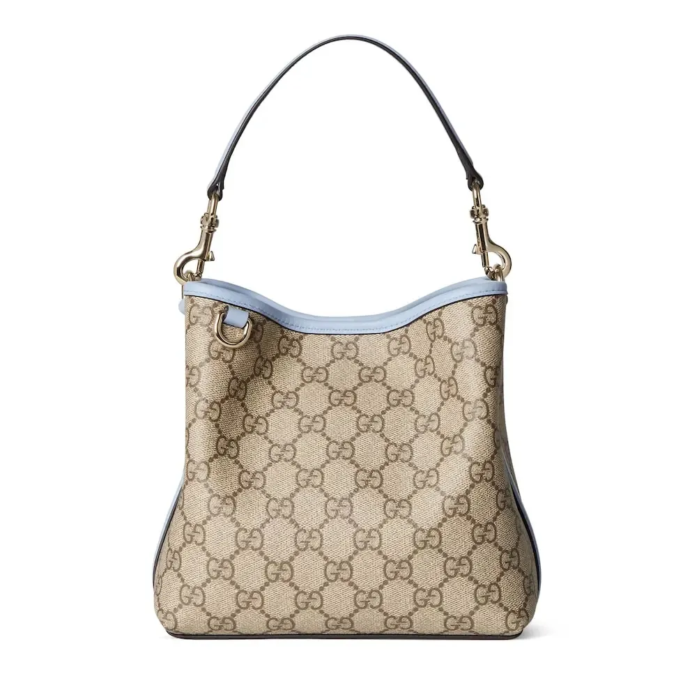 💕💕The GG Emblem series reinterprets the brand’s timeless elegance and exquisite craftsmanship. This bucket bag is lined in webbed cotton and features an internal compartment for added functionality. New GG monogram coated fabric in beige and dark brown Light blue leather trim Light gold tone hardware Red and green web cotton lining The bag pictured is sold separately and does not come with the bag charm. Top handle with hook closure (height: 14 cm) Additional D-ring for attaching removable items Interior: two compartments and a central snap-stud compartment Removable and adjustable leather shoulder strap (height: 52 cm - 57.5 cm; length: 107 cm - 114 cm) Magnetic snap closure Ident.: 815118. Dimensions: 19 cm (width) x 18 cm (height) x 11 cm (depth) Weight: about 0.45 kg Color: brown pvc/original leather. Made in Italy