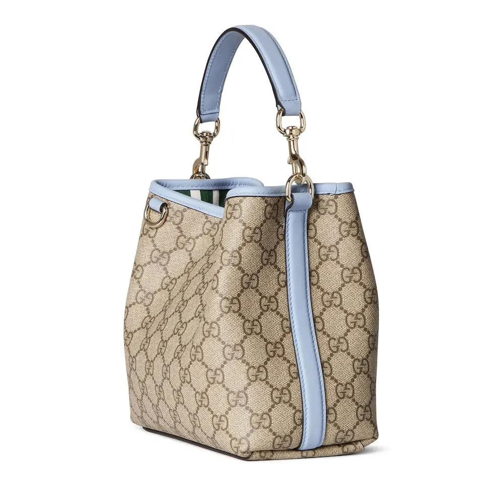 💕💕The GG Emblem series reinterprets the brand’s timeless elegance and exquisite craftsmanship. This bucket bag is lined in webbed cotton and features an internal compartment for added functionality. New GG monogram coated fabric in beige and dark brown Light blue leather trim Light gold tone hardware Red and green web cotton lining The bag pictured is sold separately and does not come with the bag charm. Top handle with hook closure (height: 14 cm) Additional D-ring for attaching removable items Interior: two compartments and a central snap-stud compartment Removable and adjustable leather shoulder strap (height: 52 cm - 57.5 cm; length: 107 cm - 114 cm) Magnetic snap closure Ident.: 815118. Dimensions: 19 cm (width) x 18 cm (height) x 11 cm (depth) Weight: about 0.45 kg Color: brown pvc/original leather. Made in Italy