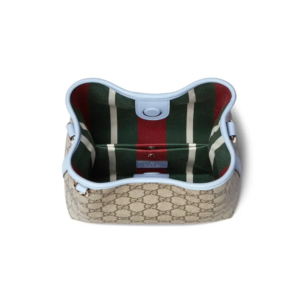 💕💕The GG Emblem series reinterprets the brand’s timeless elegance and exquisite craftsmanship. This bucket bag is lined in webbed cotton and features an internal compartment for added functionality. New GG monogram coated fabric in beige and dark brown Light blue leather trim Light gold tone hardware Red and green web cotton lining The bag pictured is sold separately and does not come with the bag charm. Top handle with hook closure (height: 14 cm) Additional D-ring for attaching removable items Interior: two compartments and a central snap-stud compartment Removable and adjustable leather shoulder strap (height: 52 cm - 57.5 cm; length: 107 cm - 114 cm) Magnetic snap closure Ident.: 815118. Dimensions: 19 cm (width) x 18 cm (height) x 11 cm (depth) Weight: about 0.45 kg Color: brown pvc/original leather. Made in Italy