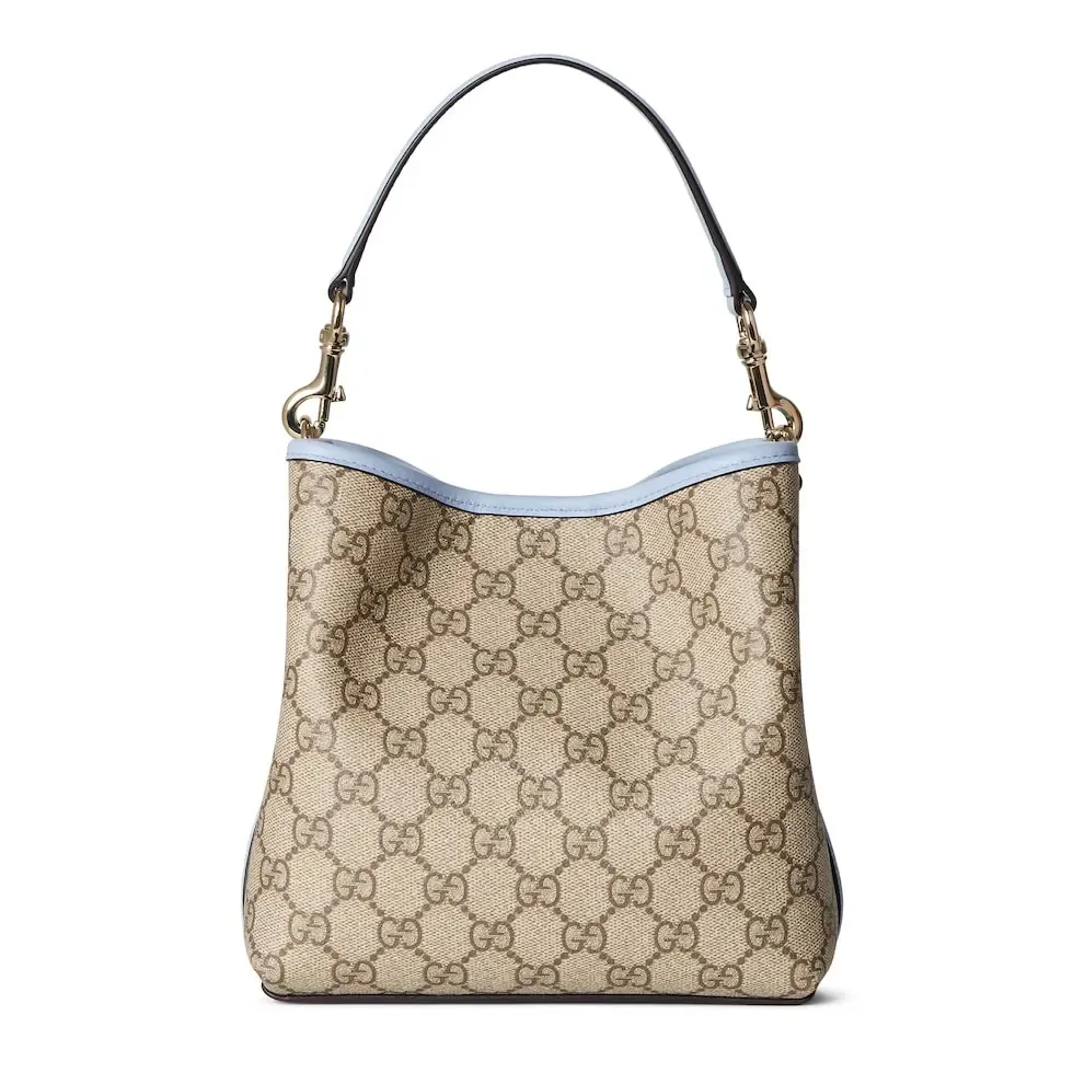 💕💕The GG Emblem series reinterprets the brand’s timeless elegance and exquisite craftsmanship. This bucket bag is lined in webbed cotton and features an internal compartment for added functionality. New GG monogram coated fabric in beige and dark brown Light blue leather trim Light gold tone hardware Red and green web cotton lining The bag pictured is sold separately and does not come with the bag charm. Top handle with hook closure (height: 14 cm) Additional D-ring for attaching removable items Interior: two compartments and a central snap-stud compartment Removable and adjustable leather shoulder strap (height: 52 cm - 57.5 cm; length: 107 cm - 114 cm) Magnetic snap closure Ident.: 815118. Dimensions: 19 cm (width) x 18 cm (height) x 11 cm (depth) Weight: about 0.45 kg Color: brown pvc/original leather. Made in Italy