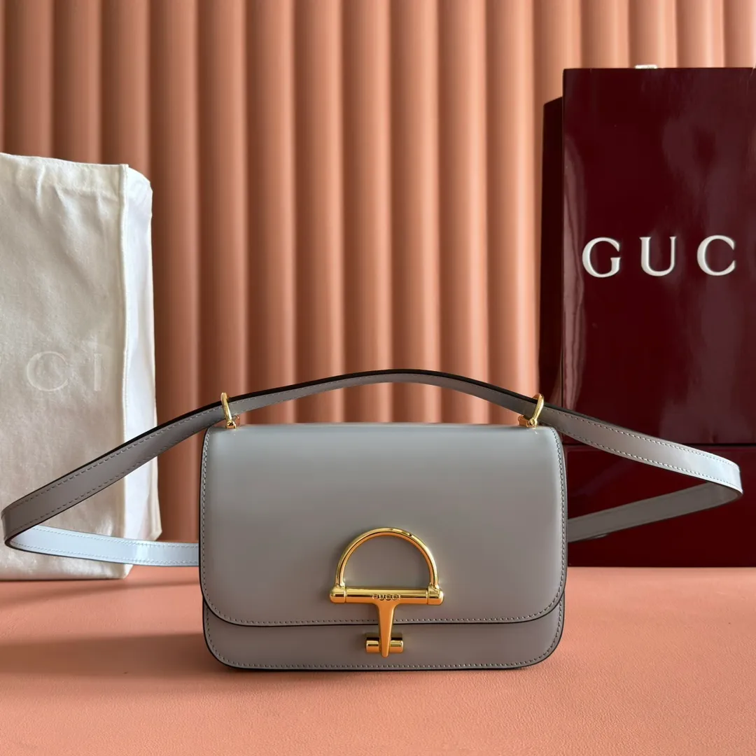 p1640. 💋💋💋【With full set of original counter packaging】2025 autumn and winter series, the Gucci Siena series small shoulder bag continues the evolution of the iconic element of Gucci's classic horsebit. Crafted from fine glossy leather, this shoulder bag has a structured shape and a half-horsebit buckle design from the 1970s. Finished with gold-tone hardware, the interior is lined with three levels of gusseting and a zipped pocket. Black fine glossy leather Gold-tone hardware Black leather lining Interior: 3-level fastening and 1 zipped pocket Shoulder straps: Height: 23cm – 25cm; Length: 127cm Half-horsebit snap fastener Ident: 846705. Dimensions: 22.5cm (width) x 14cm (height) x 8cm (depth) Weight: approx. 0.7kg Color: Gray full leather. Made in Italy