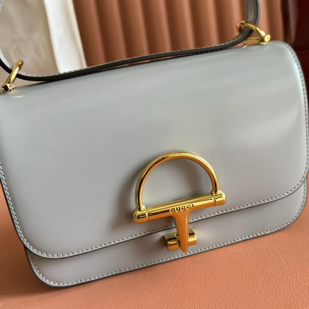 p1640. 💋💋💋【With full set of original counter packaging】2025 autumn and winter series, the Gucci Siena series small shoulder bag continues the evolution of the iconic element of Gucci's classic horsebit. Crafted from fine glossy leather, this shoulder bag has a structured shape and a half-horsebit buckle design from the 1970s. Finished with gold-tone hardware, the interior is lined with three levels of gusseting and a zipped pocket. Black fine glossy leather Gold-tone hardware Black leather lining Interior: 3-level fastening and 1 zipped pocket Shoulder straps: Height: 23cm – 25cm; Length: 127cm Half-horsebit snap fastener Ident: 846705. Dimensions: 22.5cm (width) x 14cm (height) x 8cm (depth) Weight: approx. 0.7kg Color: Gray full leather. Made in Italy