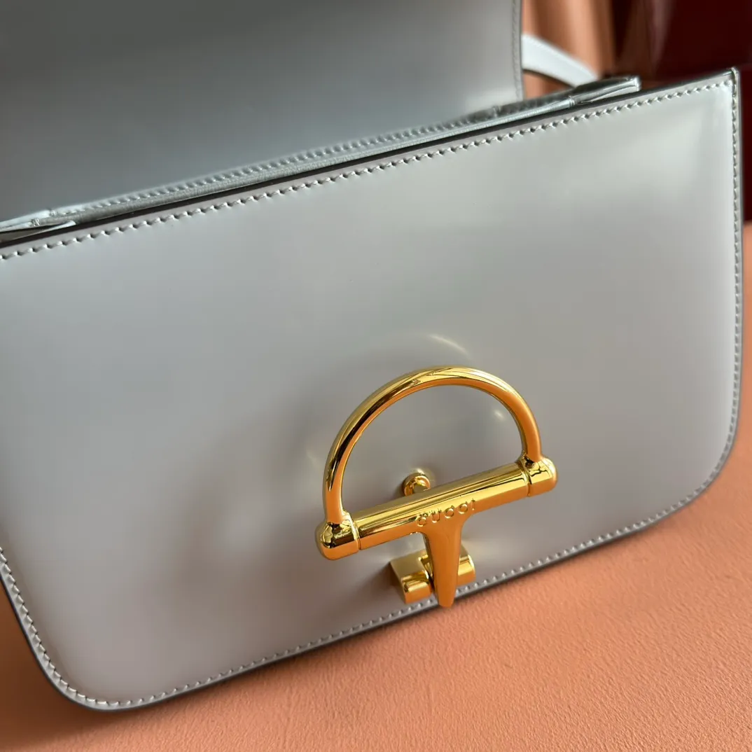 p1640. 💋💋💋【With full set of original counter packaging】2025 autumn and winter series, the Gucci Siena series small shoulder bag continues the evolution of the iconic element of Gucci's classic horsebit. Crafted from fine glossy leather, this shoulder bag has a structured shape and a half-horsebit buckle design from the 1970s. Finished with gold-tone hardware, the interior is lined with three levels of gusseting and a zipped pocket. Black fine glossy leather Gold-tone hardware Black leather lining Interior: 3-level fastening and 1 zipped pocket Shoulder straps: Height: 23cm – 25cm; Length: 127cm Half-horsebit snap fastener Ident: 846705. Dimensions: 22.5cm (width) x 14cm (height) x 8cm (depth) Weight: approx. 0.7kg Color: Gray full leather. Made in Italy