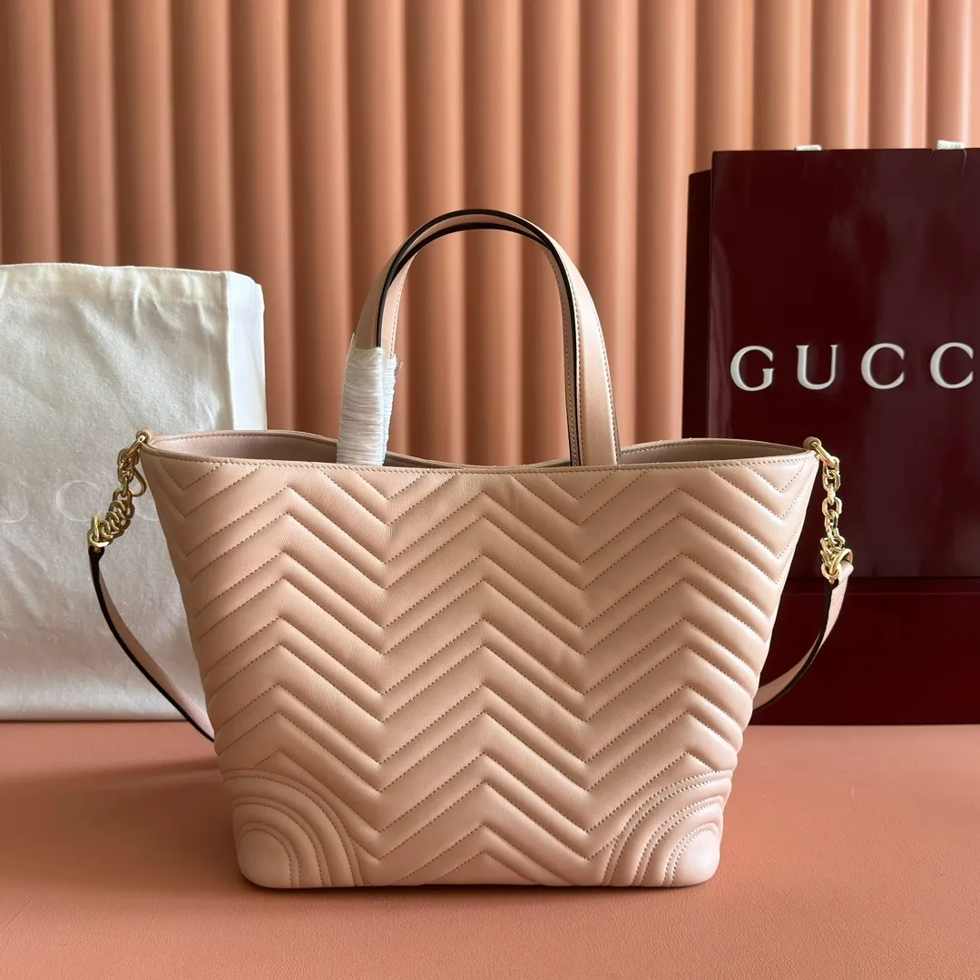 p1400. 💋💋💋 Comes with a complete set of original counter packaging [New product] This tote bag injects novel charm into the GG Marmont series with a new silhouette in the 2025 autumn and winter series. It can transform from a structural tote bag to a soft-lined bucket bag. The shape is paired with top handles and chain shoulder straps, presenting a variety of fashion styling options. Black V-shaped quilted sheepskin. Light gold-tone hardware. Gucci ankara red viscose lining. Double G. Interior: Zip pocket. Handle drop 14 cm. Shoulder strap drop 53 cm (bag closed: 48 cm). Ident.: 847387. Dimensions: 28cm (bottom width) x 39cm (top width) x 24cm (height) x 16cm (depth) Weight: approx. 0.7kg Color: pink sheepskin. Made in Italy