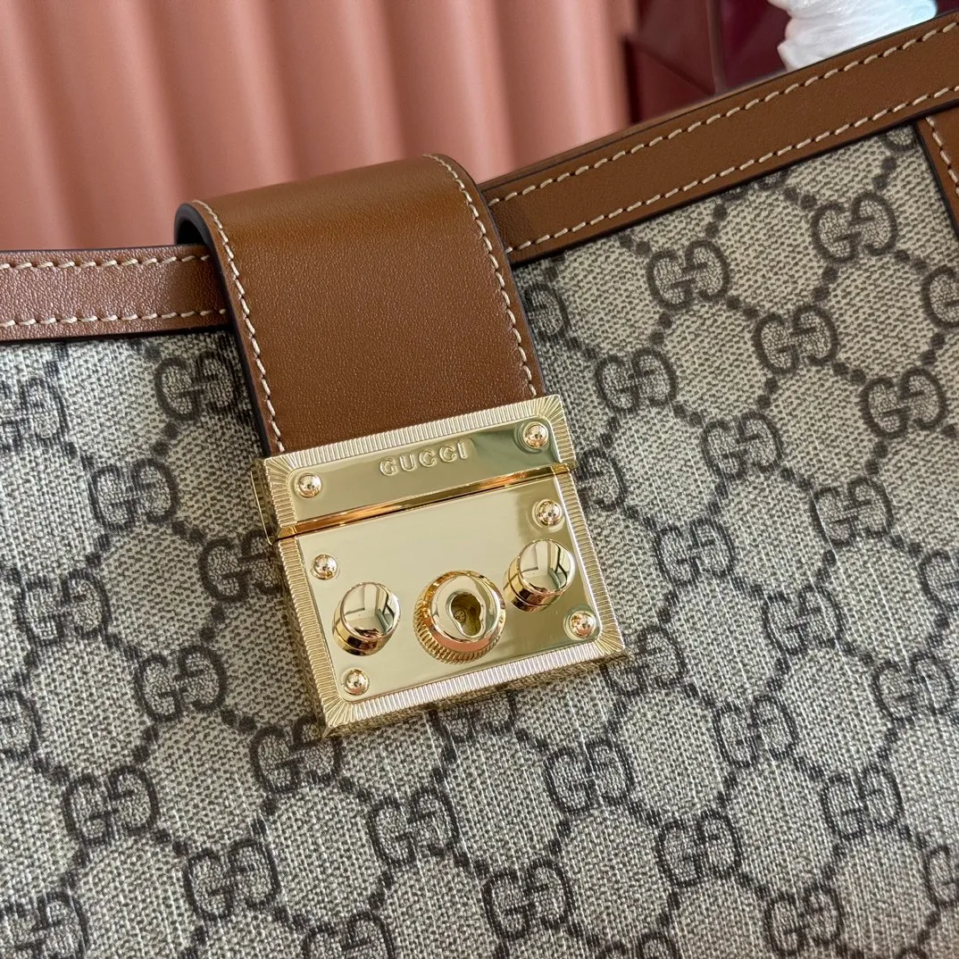 p1100💋💋💋【Original leather configuration counter complete package】The Padlock series has launched a variety of fashionable bags with various carrying methods, adding color to the 2025 early autumn series. This tote is lined with webbing, reminiscent of the brand's signature pattern. Beige and dark brown GG monogram coated fabric Brown leather trim Light gold tone hardware Red and green webbing cotton lining Interior: One zippered pocket Carry handle (10 cm height) Removable and adjustable leather shoulder strap (height: 114 cm - 124 cm; length: 55 cm - 60 cm) Padlock closure with leather keychain Ident.: 838992. Dimensions: 25.5cm (width) x 17.5cm (height) x 10cm (depth) Weight: approx. 0.6kg Color: brown pvc. Made in Italy