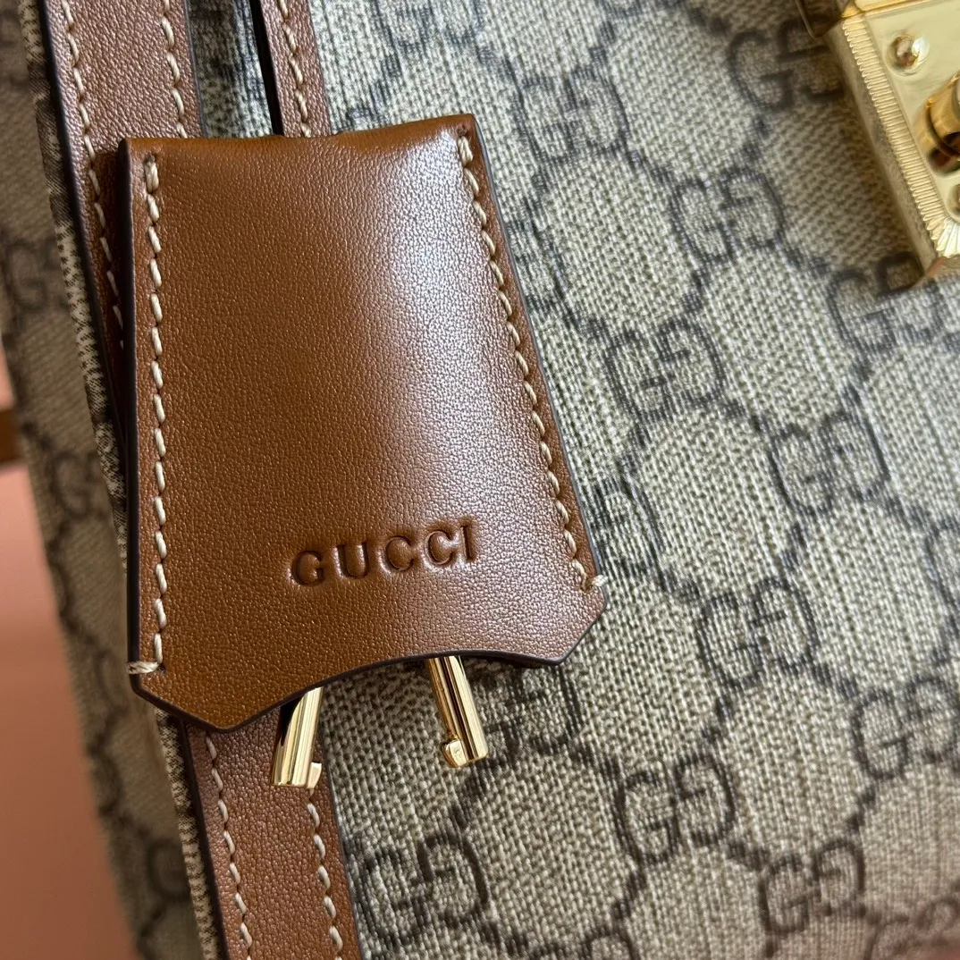 p1100💋💋💋【Original leather configuration counter complete package】The Padlock series has launched a variety of fashionable bags with various carrying methods, adding color to the 2025 early autumn series. This tote is lined with webbing, reminiscent of the brand's signature pattern. Beige and dark brown GG monogram coated fabric Brown leather trim Light gold tone hardware Red and green webbing cotton lining Interior: One zippered pocket Carry handle (10 cm height) Removable and adjustable leather shoulder strap (height: 114 cm - 124 cm; length: 55 cm - 60 cm) Padlock closure with leather keychain Ident.: 838992. Dimensions: 25.5cm (width) x 17.5cm (height) x 10cm (depth) Weight: approx. 0.6kg Color: brown pvc. Made in Italy