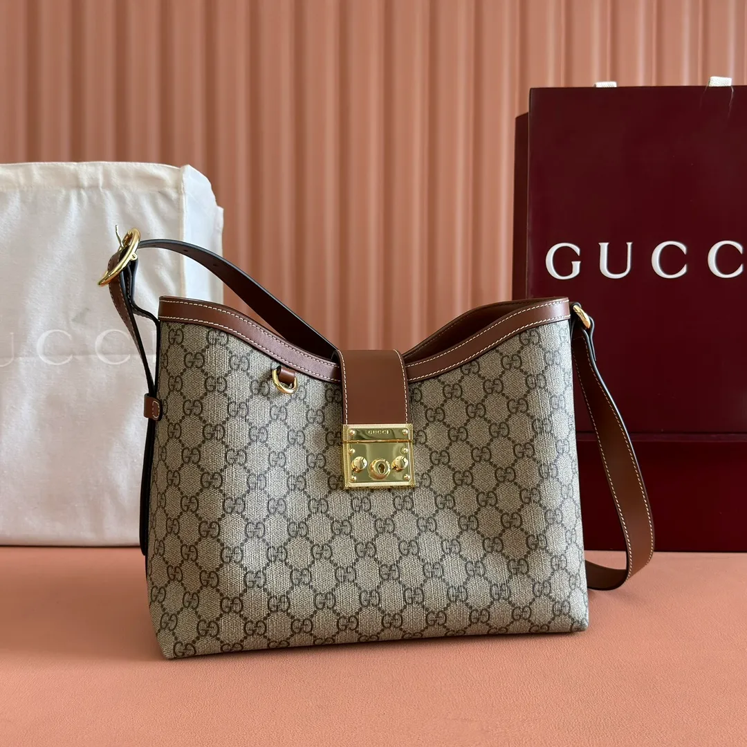 p1120💋💋💋【Full set of packaging at the counter】The Padlock series has launched a variety of fashionable bags with various carrying methods, adding color to the 2025 early autumn series. This shoulder bag features a central compartment with a zip pocket and is lined with webbing, reminiscent of the brand's signature pattern. Beige and dark brown GG monogram coated fabric Brown leather trim Light gold tone hardware Red and green web cotton lining Interior: Middle compartment with zip pocket Adjustable shoulder strap (44 cm high) Padlock closure with leather keychain Ref.: 839021. Dimensions: 29 cm (width) x 23.5 cm (height) x 15.5 cm (depth) Weight: about 0.75 kg Color: Brown PVC/original leather. Made in Italy