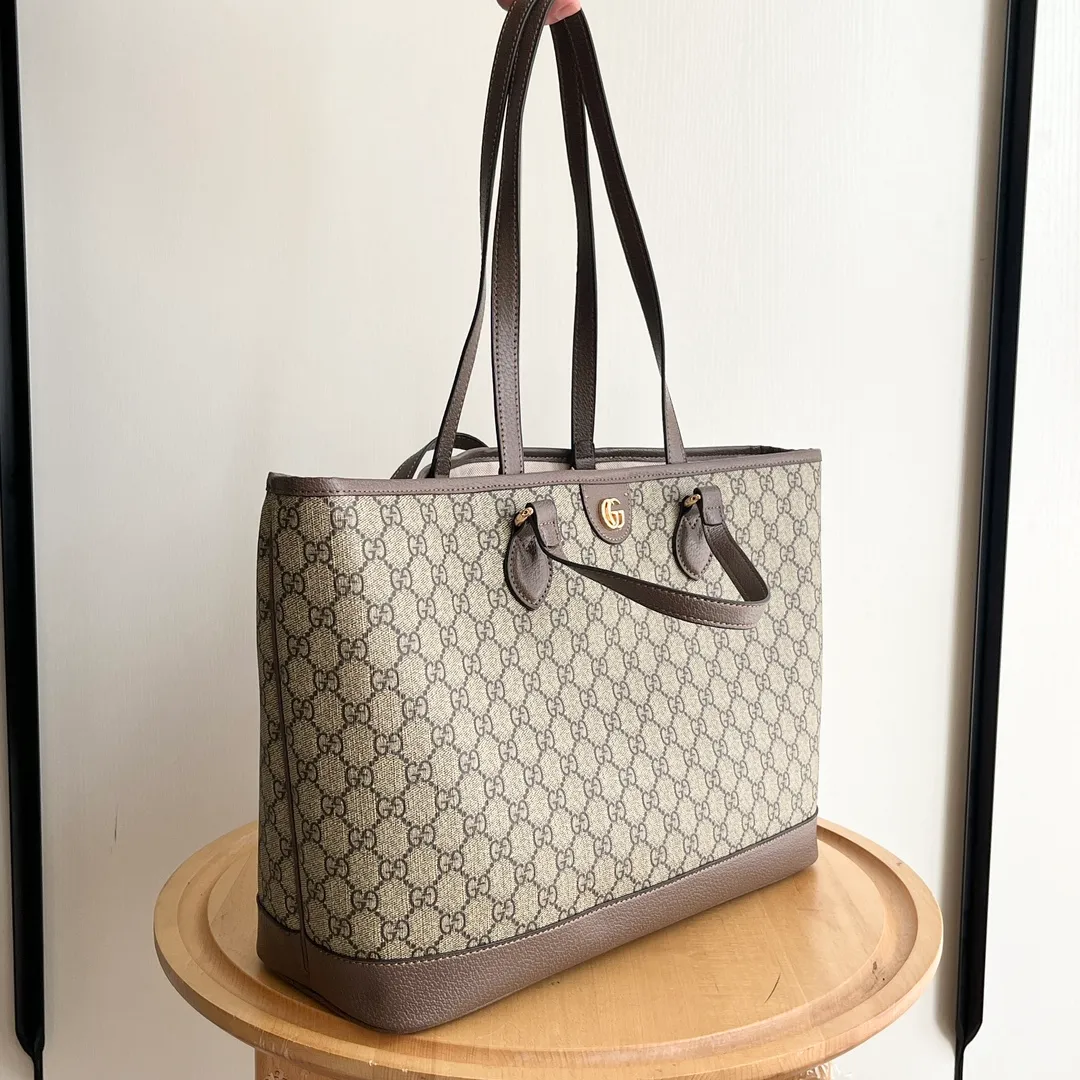 Actual shot #💰300 Model: 739730 Size: 38.5x28.5x15cm The GG Ophidia series is still one of Gucci’s iconic handbags. The brand launches new styles every season, creating versatile accessories that suit every look. Two handles give this tote a multi-functional character, allowing it to be worn as a shoulder bag or as a handbag. As a classic design element, the Double G has been deeply embedded in the brand's design. On this handbag, it is presented in a dazzling manner, contrasting with the GG Supreme canvas and brown leather piping.