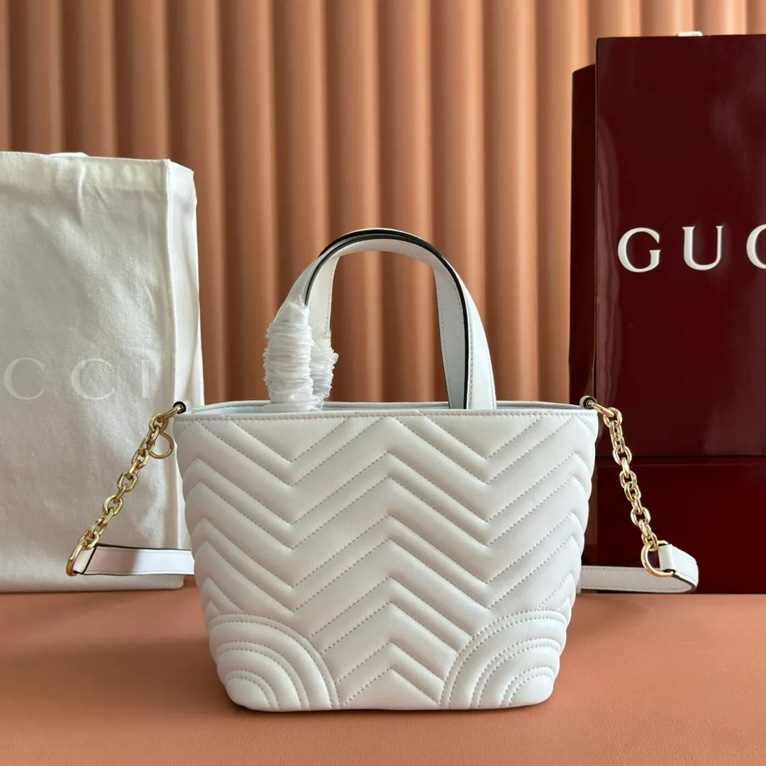 p1280. 💋💋💋 Comes with a complete set of original counter packaging [New product] This tote bag injects novel charm into the GG Marmont series with a new silhouette in the 2025 autumn and winter series. It can transform from a structural tote bag to a soft-lined bucket bag. The shape is paired with top handles and chain shoulder straps, presenting a variety of fashion styling options. White chevron quilted sheepskin Light gold-tone hardware Gucci ankara red viscose lining Double G Interior: Open pocket Handle drop 11 cm Shoulder strap drop 53 cm (bag closed: 45 cm) Ident.: 847386. Dimensions: 18cm (bottom width) x 29cm (top width) x 18cm (height) x 12.5cm (depth) Weight: approx. 0.4kg Color: White sheepskin. Made in Italy