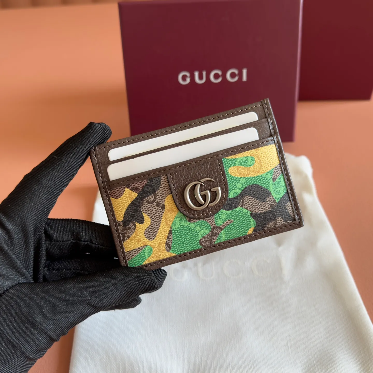 p300. 💋💋💋【With full set of original counter packaging】Vivid camouflage combined with unique color matching, a new interpretation of the classic GG pattern. This card holder is made of coated fabric with a marbled GG monogram pattern and features Double G details. Green and yellow camouflage marbled GG monogram coated fabric Brown leather trim Palladium tone hardware Brown taffeta lining Double G Web detail Interior: 1 open compartment Exterior: 4 card compartments Ident No.: 834795. Dimensions: 11cm (width) x 7cm (height) Weight: approx. 30g Color: green camouflage/pvc. Made in Italy